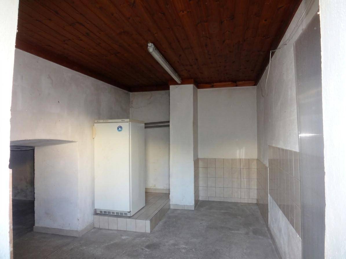 Kellerraum mit Betonboden, Kühlschrank und Holzdecke, vielseitig nutzbar.