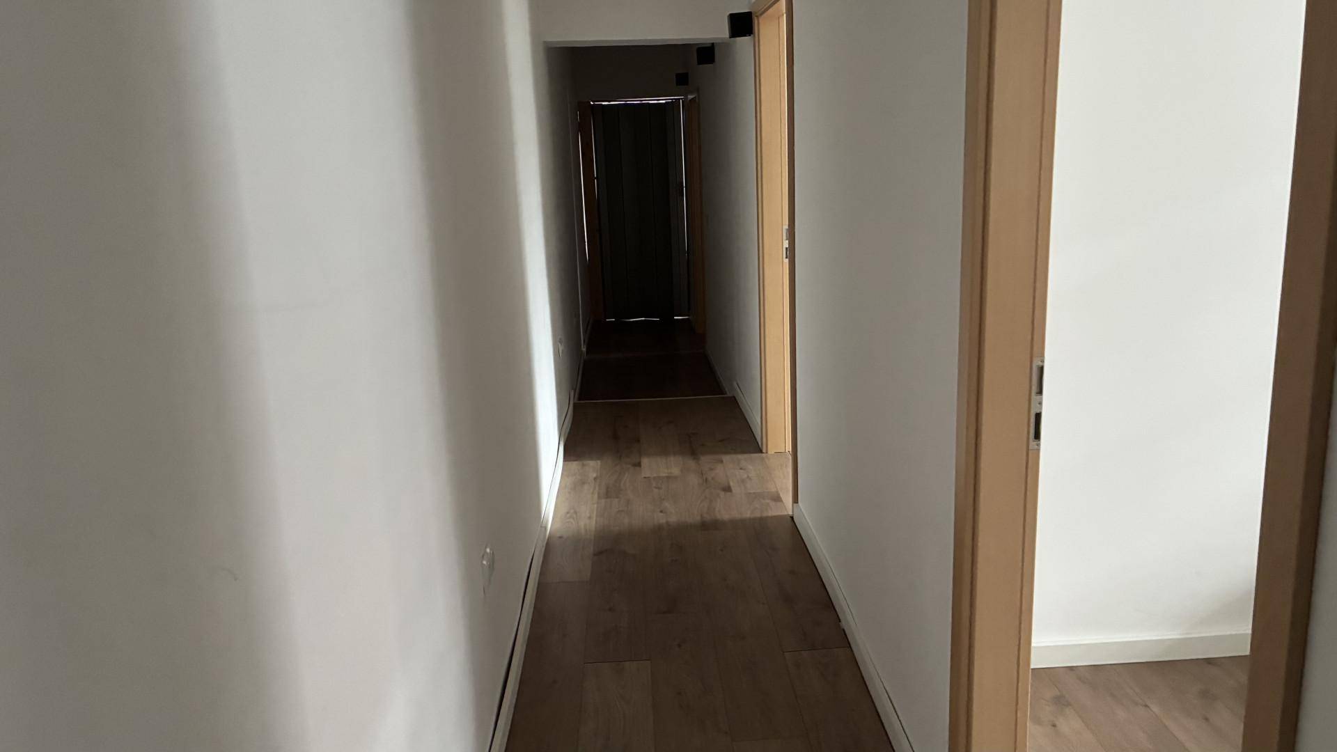 Heller Flur mit Holzboden und Türen, die zu weiteren Räumen führen.