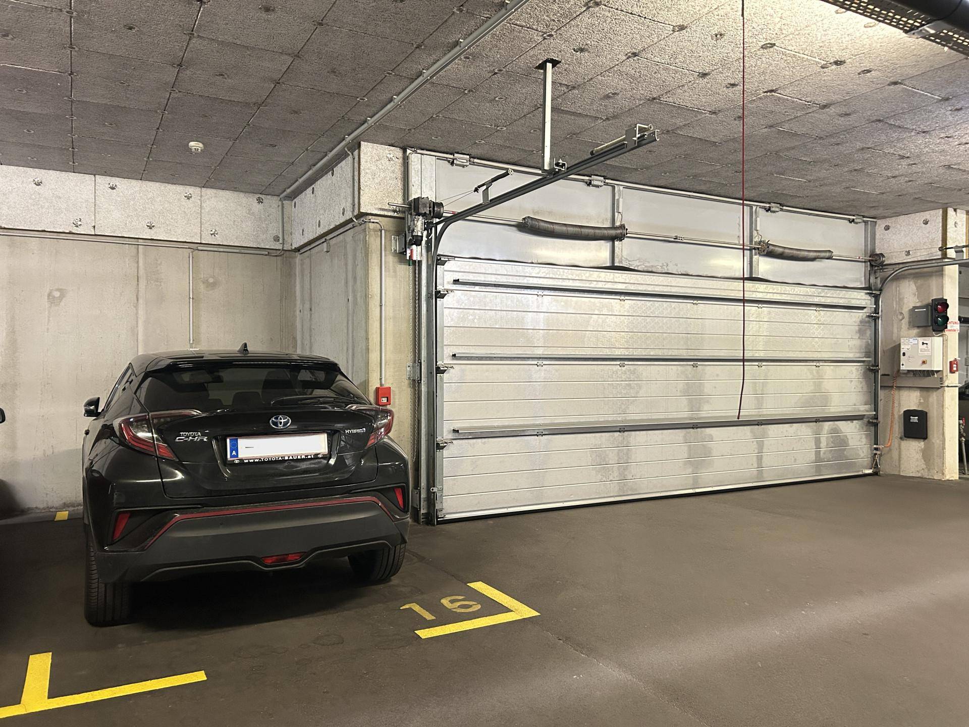 Tiefgarage mit einem geparkten Auto und einem großen Garagentor.