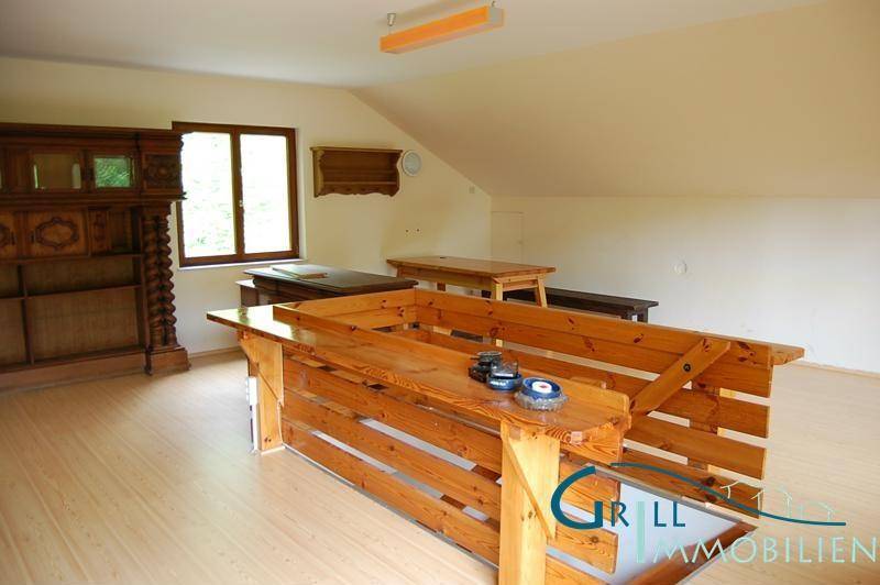 Geräumiger Wohnbereich mit Laminatboden und rustikaler Holztheke, ideal für gesellige Runden.