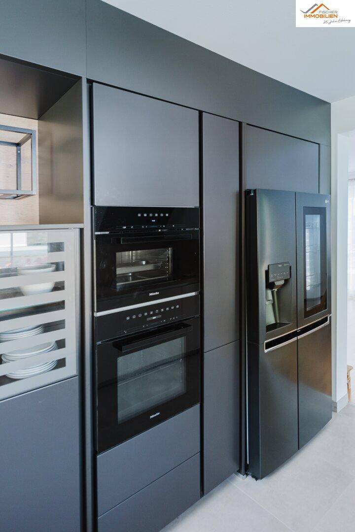 Detailansicht der modernen Einbauküche mit integrierten Backöfen und großem Kühlschrank.