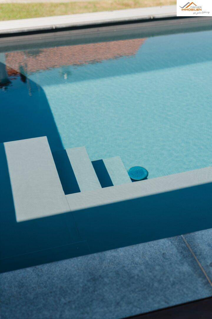 Nahaufnahme der eleganten Treppe im Pool mit klarem, blauem Wasser an einem sonnigen Tag.