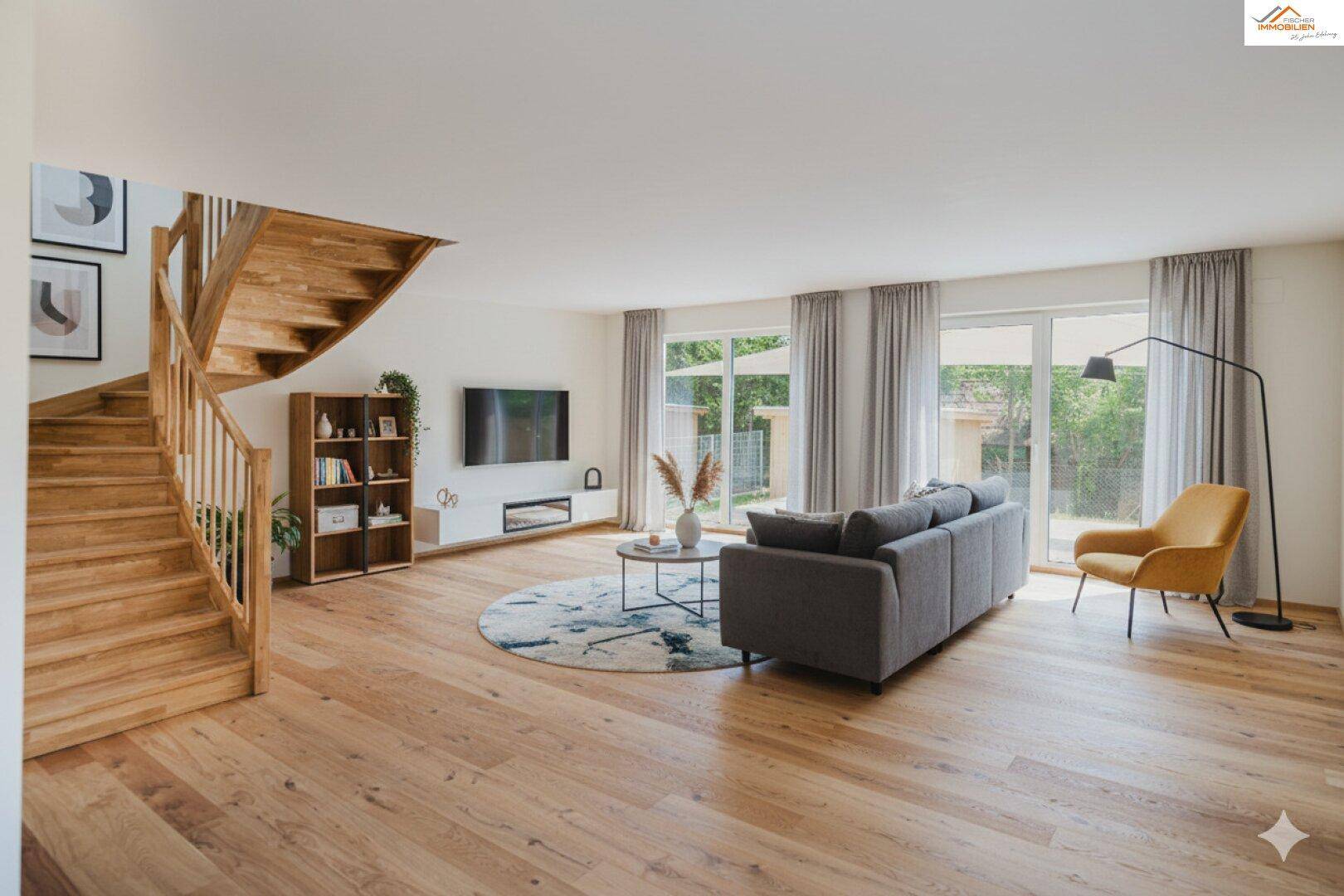 Geräumiges Wohnzimmer mit Holzboden, offener Holztreppe und Zugang zum Garten.
