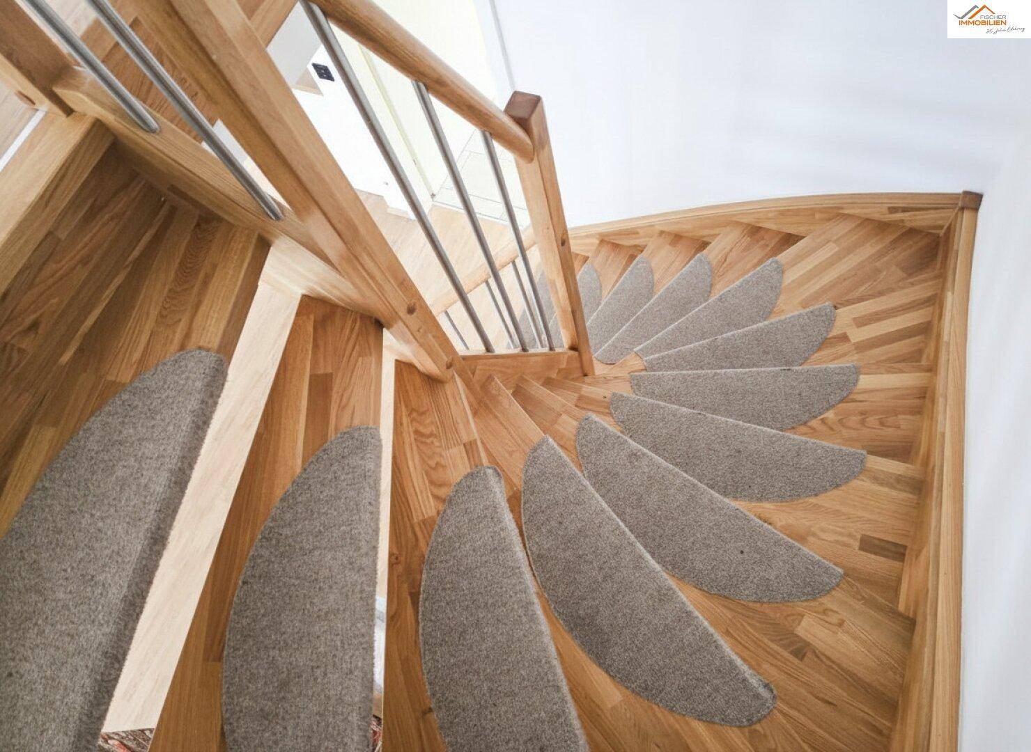 Elegante Holztreppe mit Teppichstufen und modernem Geländer, die in die obere Etage führt.