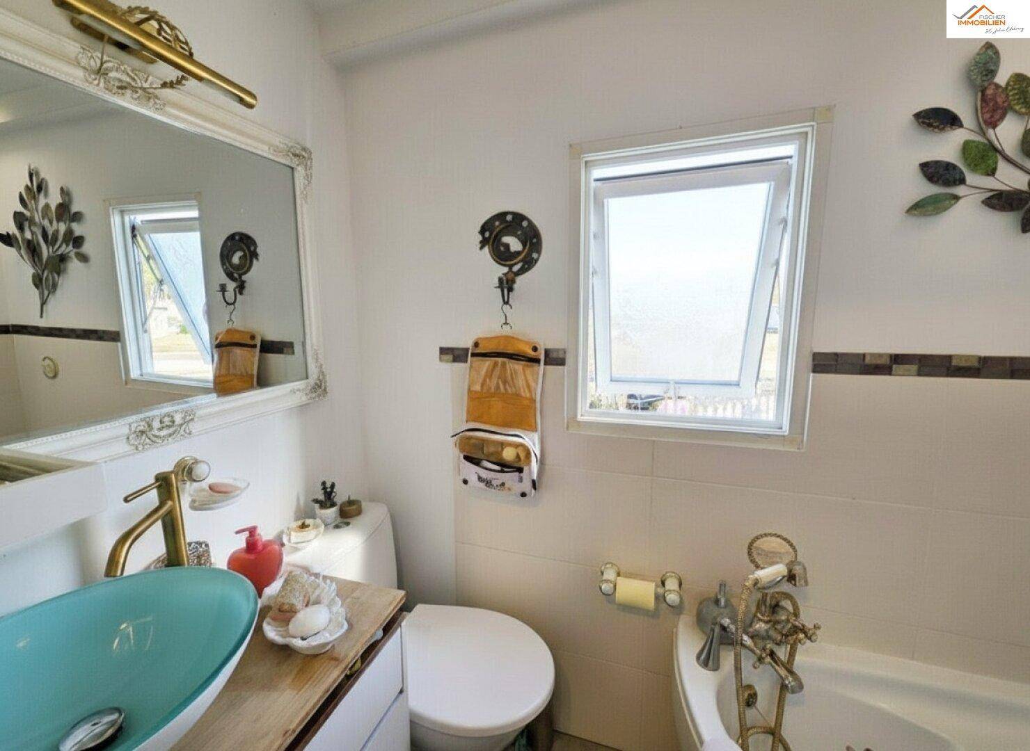 Badezimmer mit modernem Aufsatzwaschbecken, Spiegel und Fenster für Tageslicht.