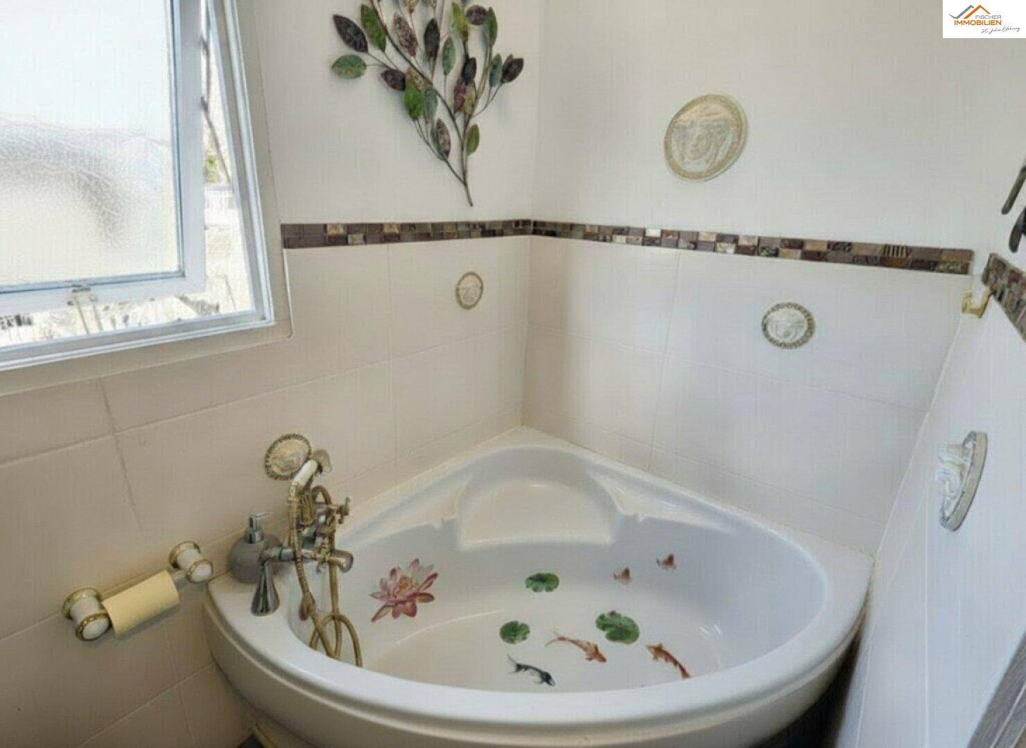 Eckbadewanne mit verspielten Dekorationen und Fliesen an den Wänden.
