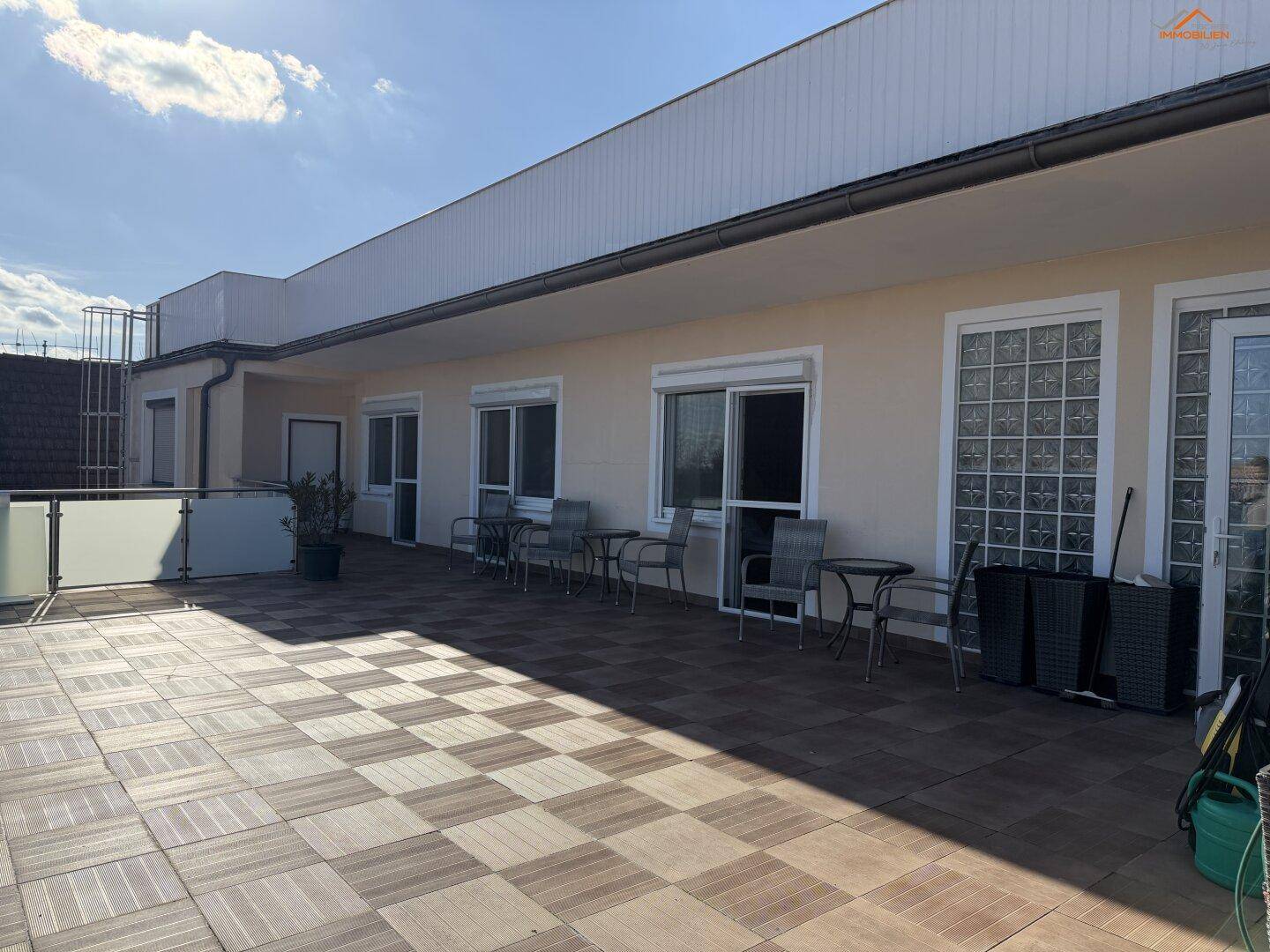 Geräumige Dachterrasse mit Fliesenboden und mehreren Zugängen zu den Zimmern.