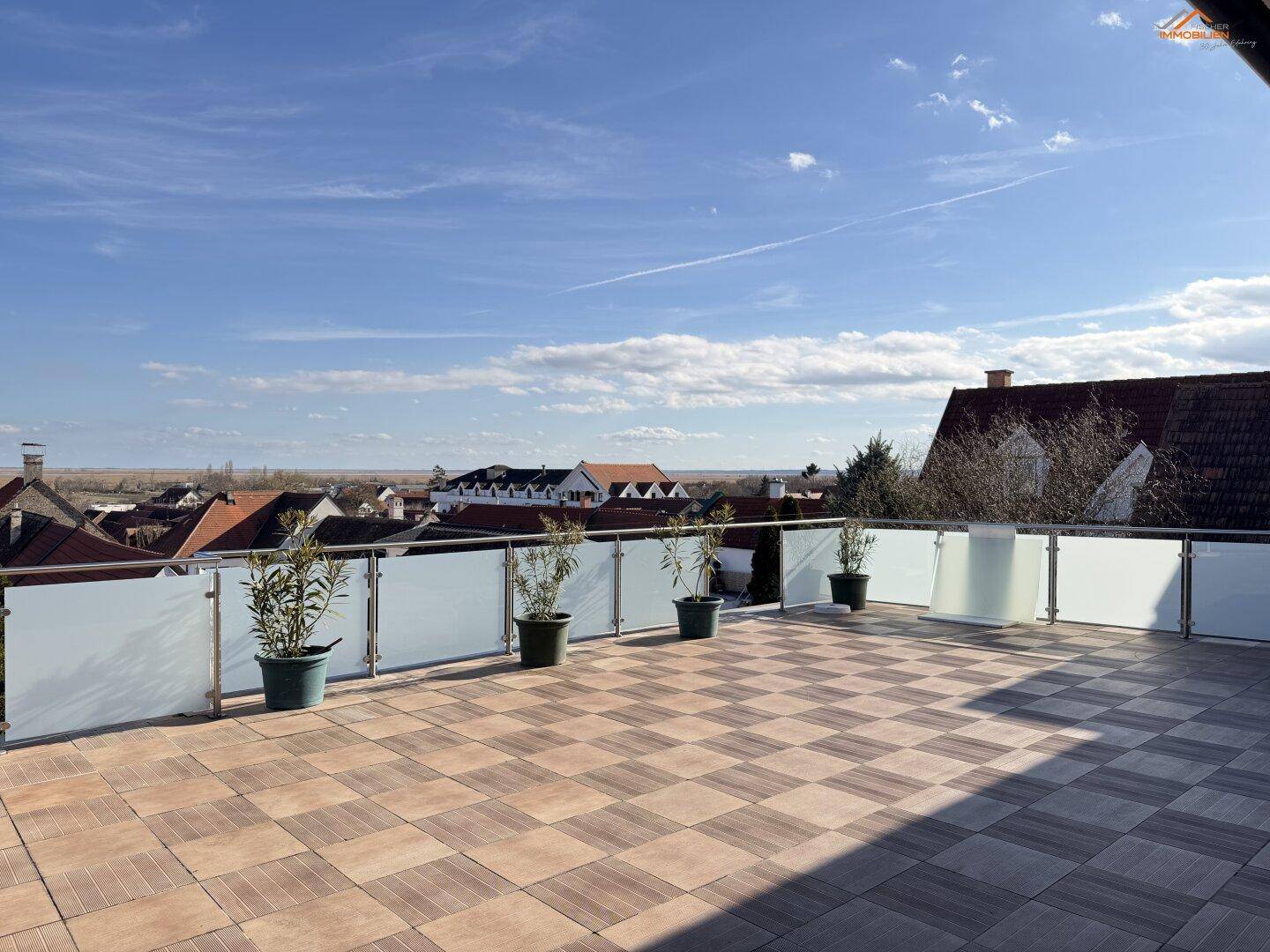 Dachterrasse mit moderner Glasbrüstung und weitem Blick über die Landschaft.