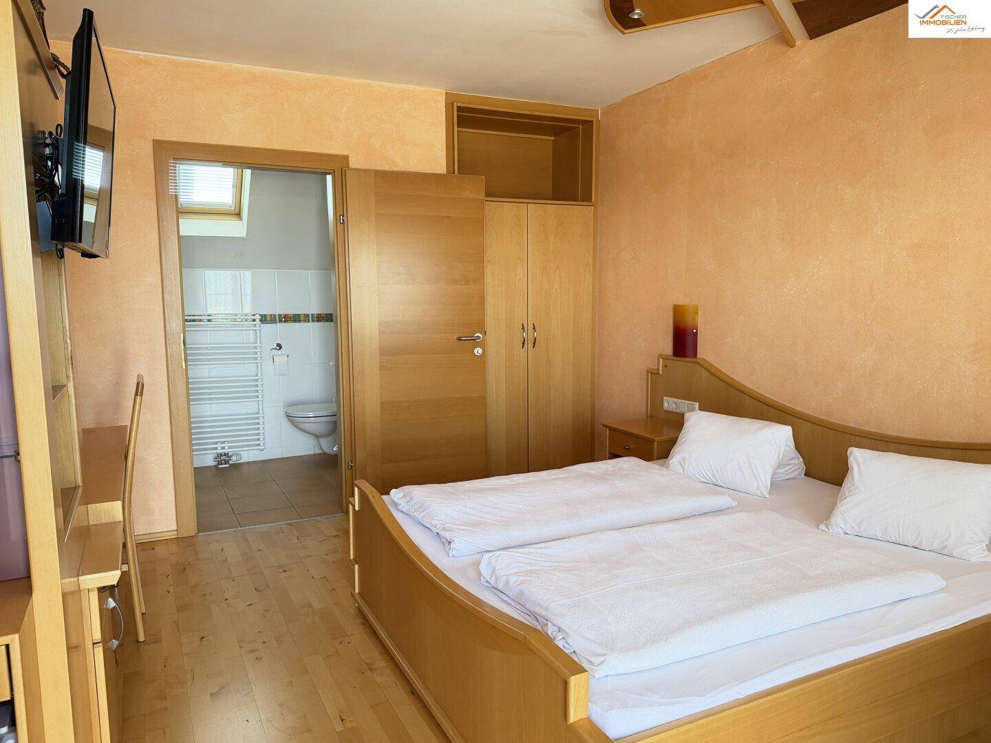 Badezimmer mit Duschkabine, beheiztem Handtuchhalter und Dachfenster.