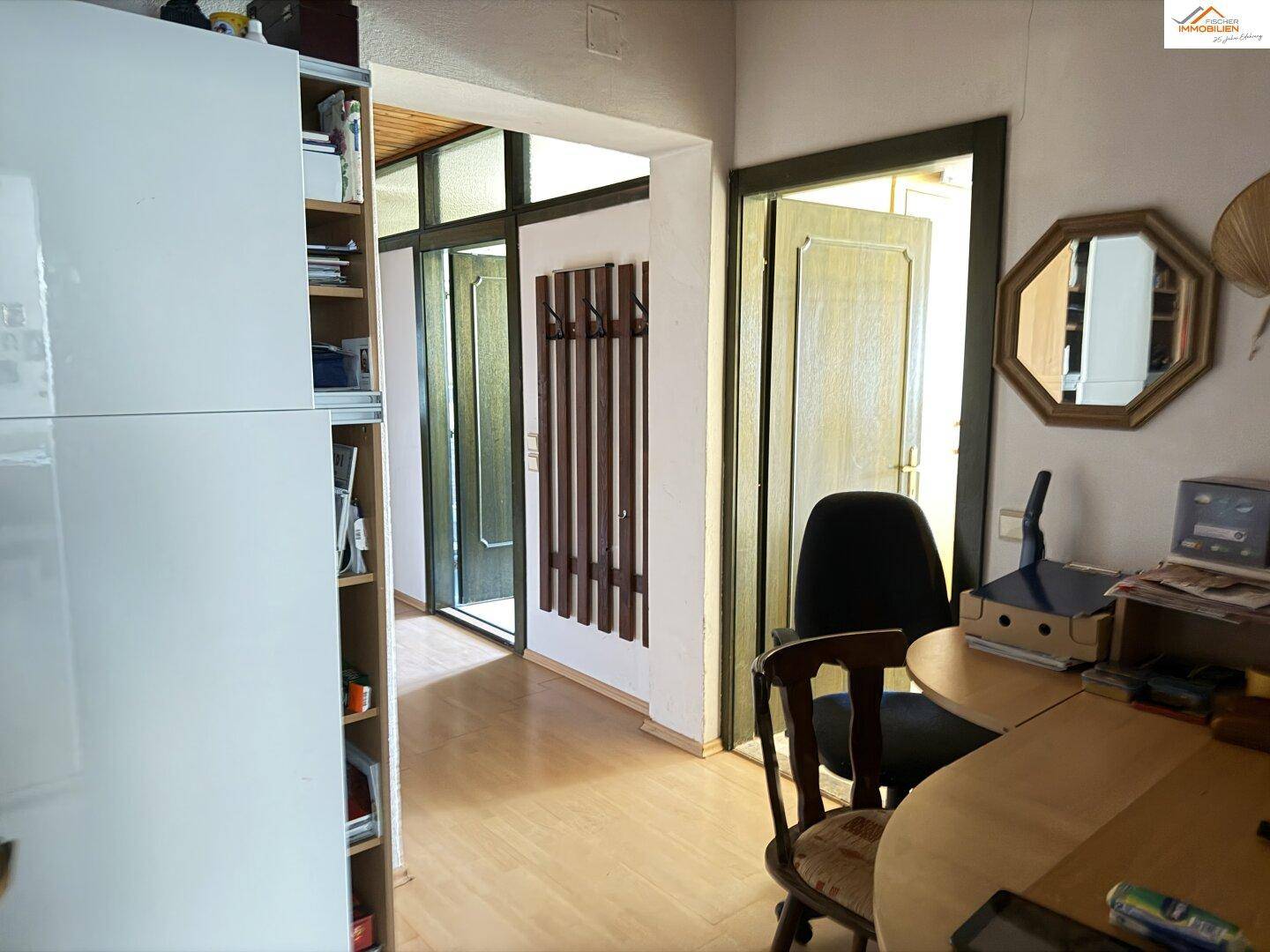 Schlafzimmer mit Doppelbett, Holzboden und Fenster mit Vorhängen.
