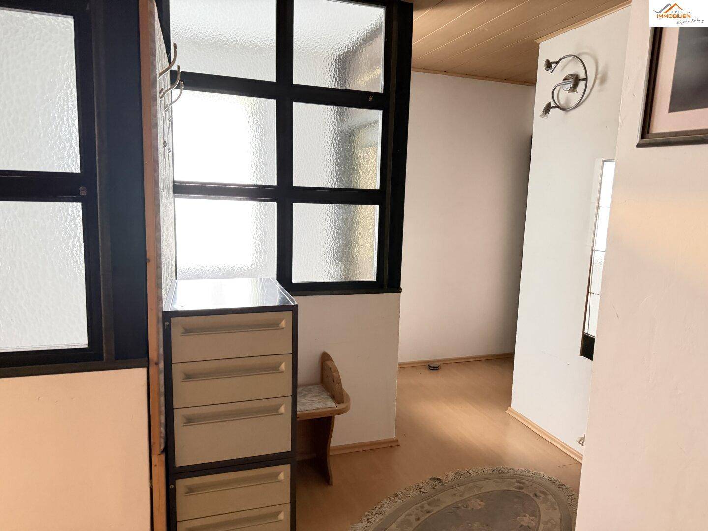 Geräumiges Büro mit mehreren Arbeitsplätzen und Glasbausteinfenster.