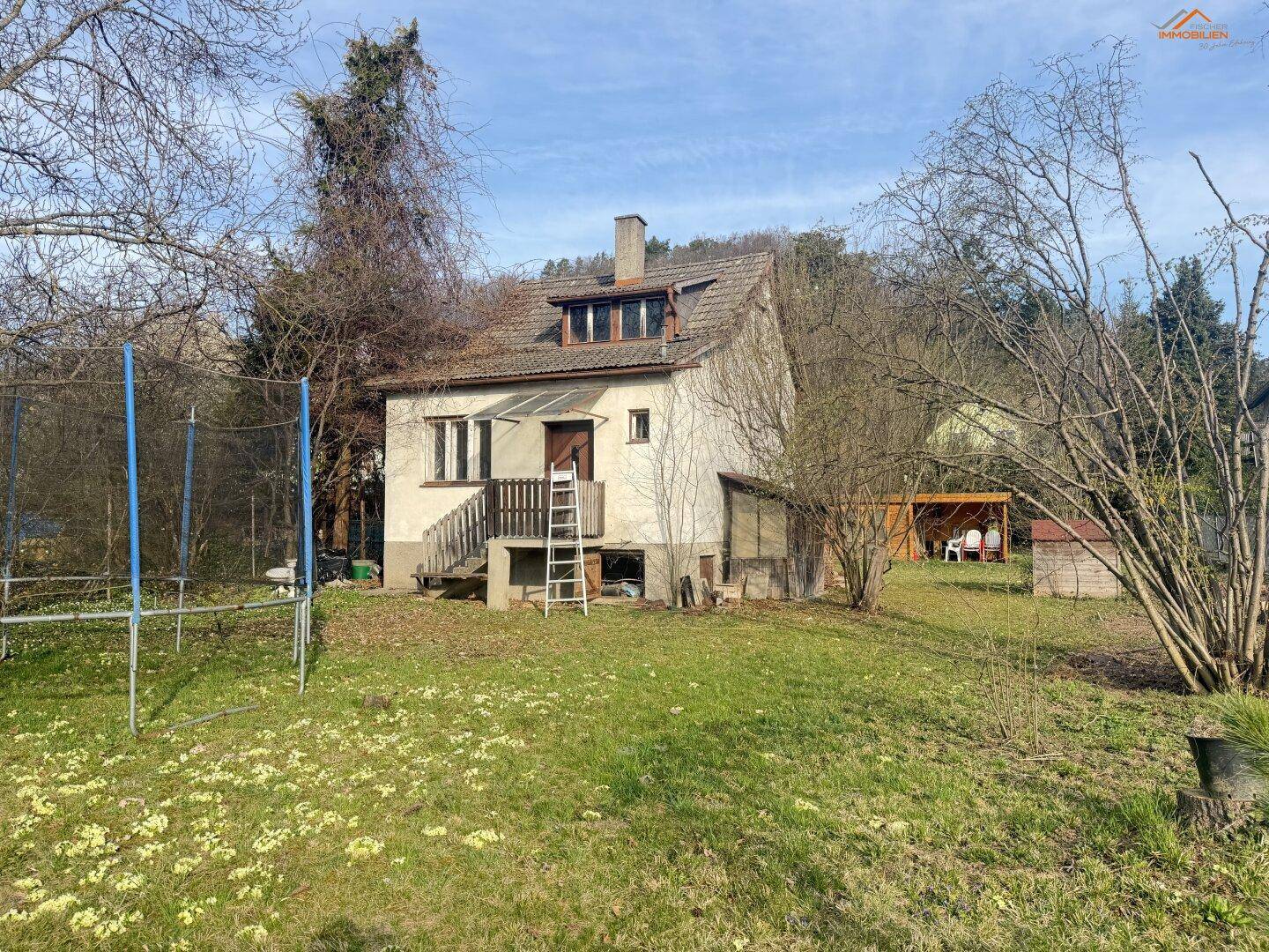 Traditionelles Einfamilienhaus mit Satteldach und Gaubenfenstern, umgeben von einem weitläufigen Garten.