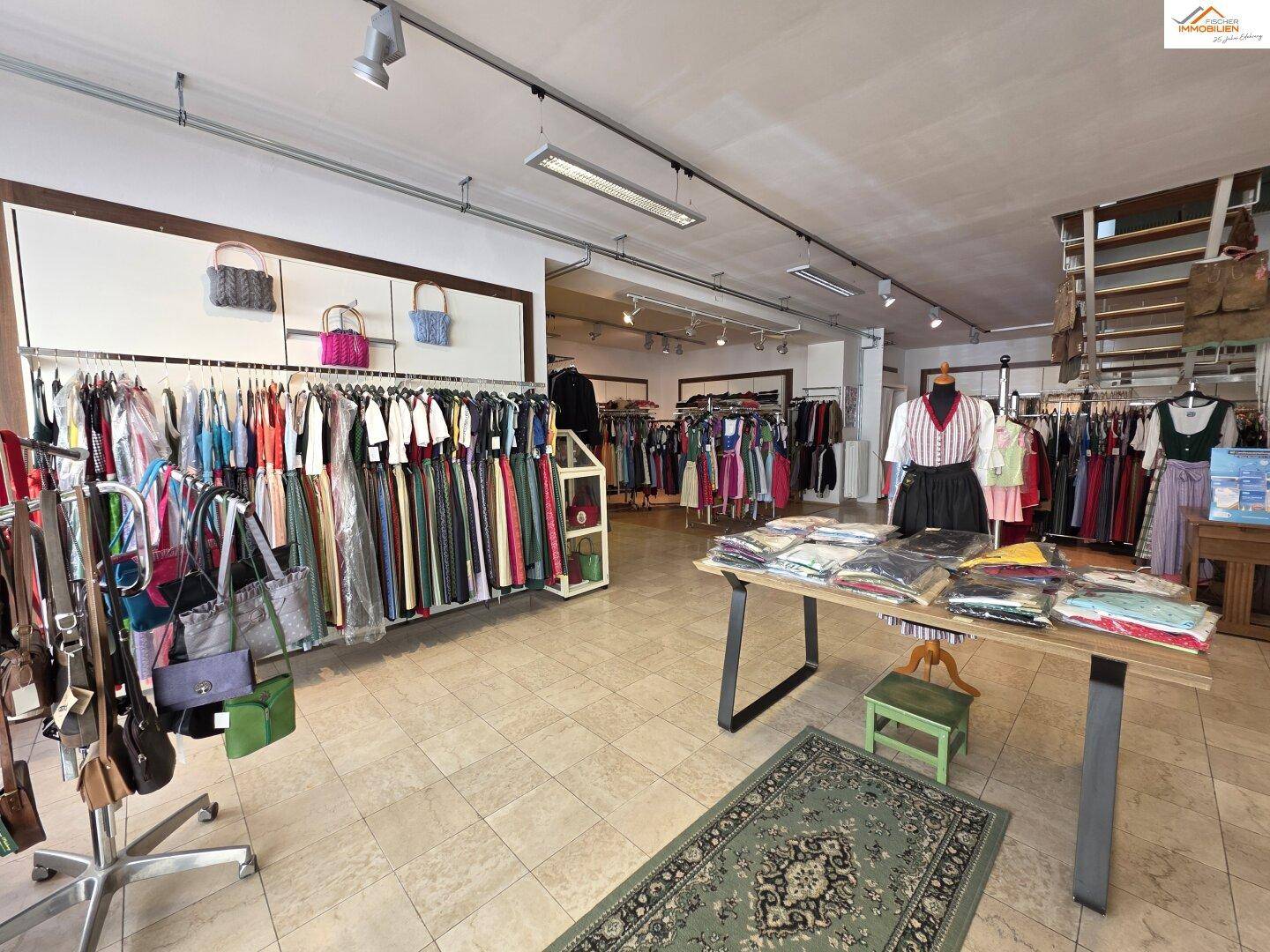 Heller Verkaufsraum mit Fliesenboden, gefüllt mit traditioneller Kleidung und Accessoires.