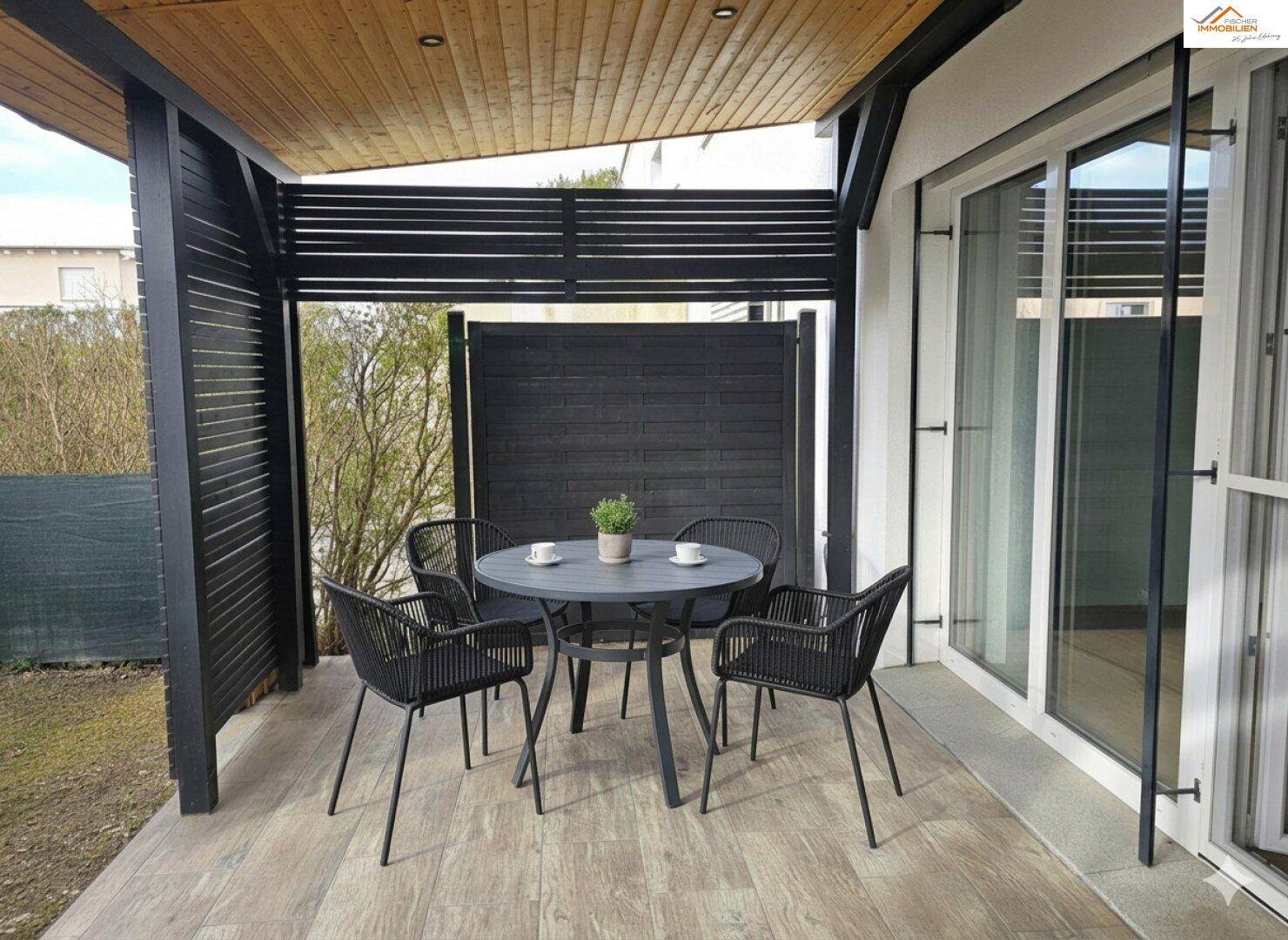 Überdachte Terrasse mit modernen Gartenmöbeln und Holzakzenten im Außenbereich.