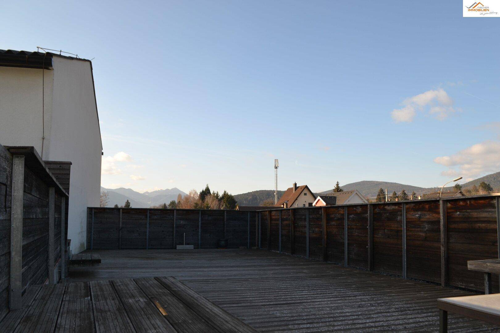 Große Holzterrasse mit Bergblick und viel Platz für Outdoor-Aktivitäten.