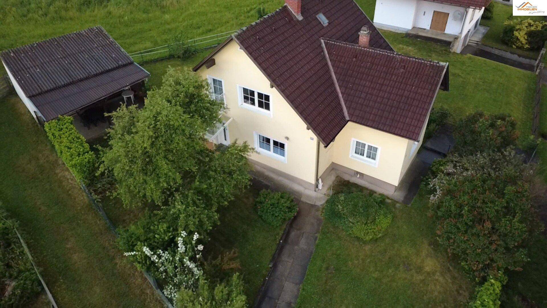 Vogelperspektive des Anwesens mit Wohnhaus, Carport und weitläufigem Gartenbereich.