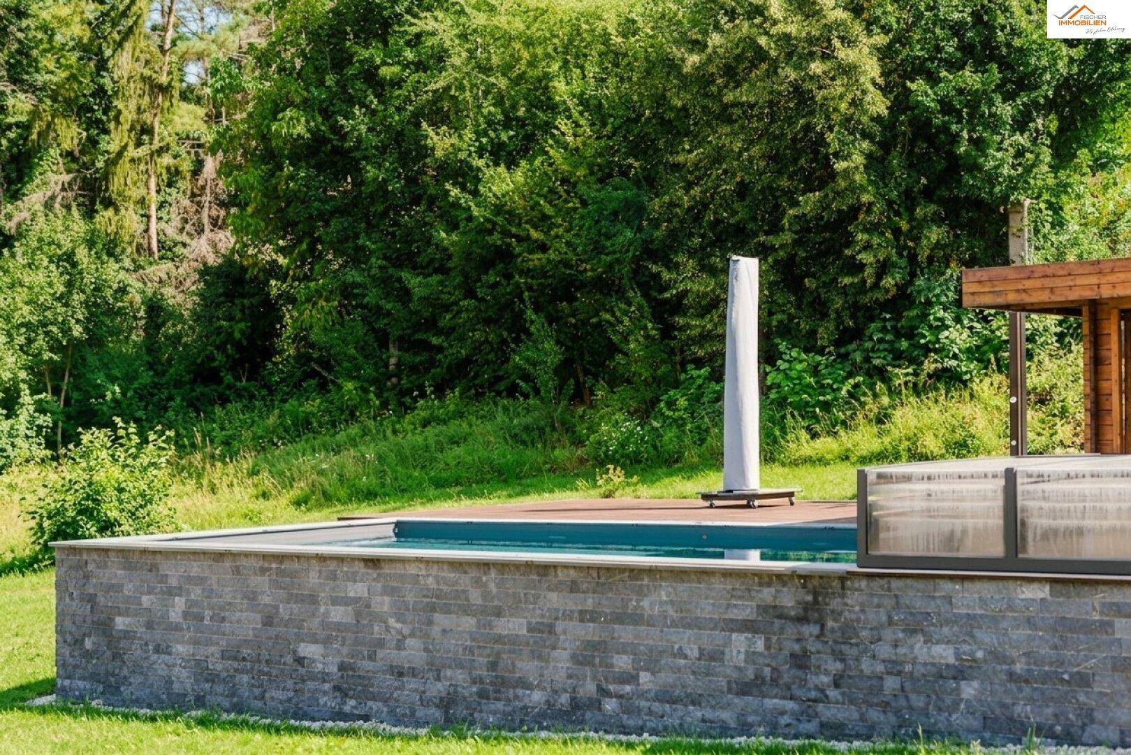 Der einladende Swimmingpool, umgeben von üppiger grüner Vegetation und Bäumen.