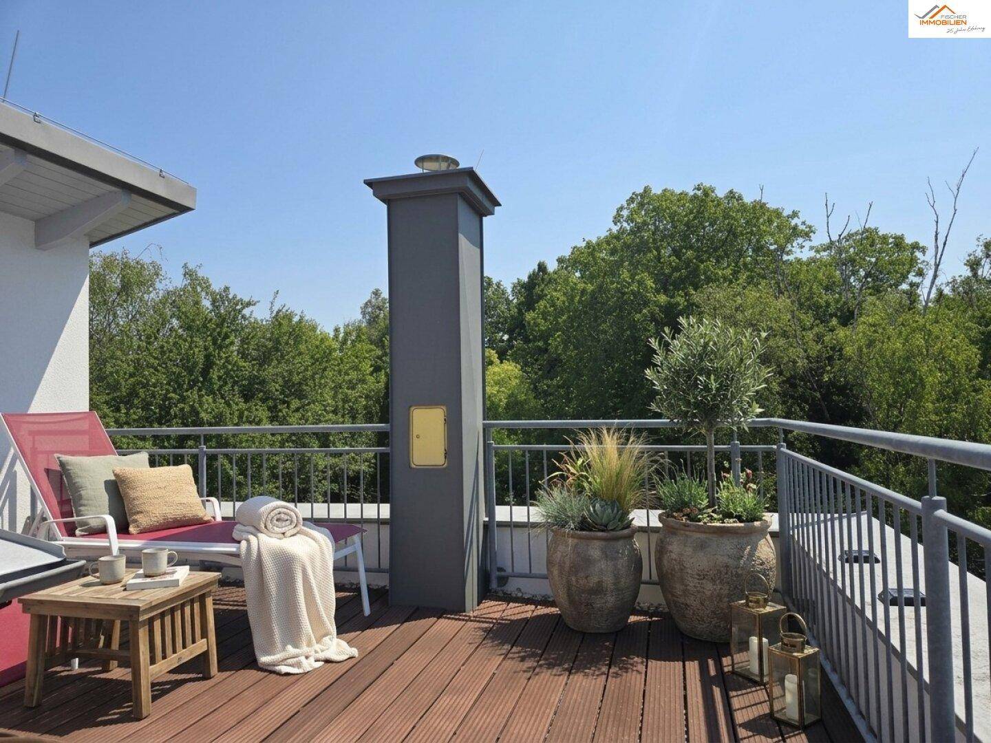 Geräumige Dachterrasse mit Holzbelag, Liegestuhl und Pflanzen, ideal zum Sonnenbaden.