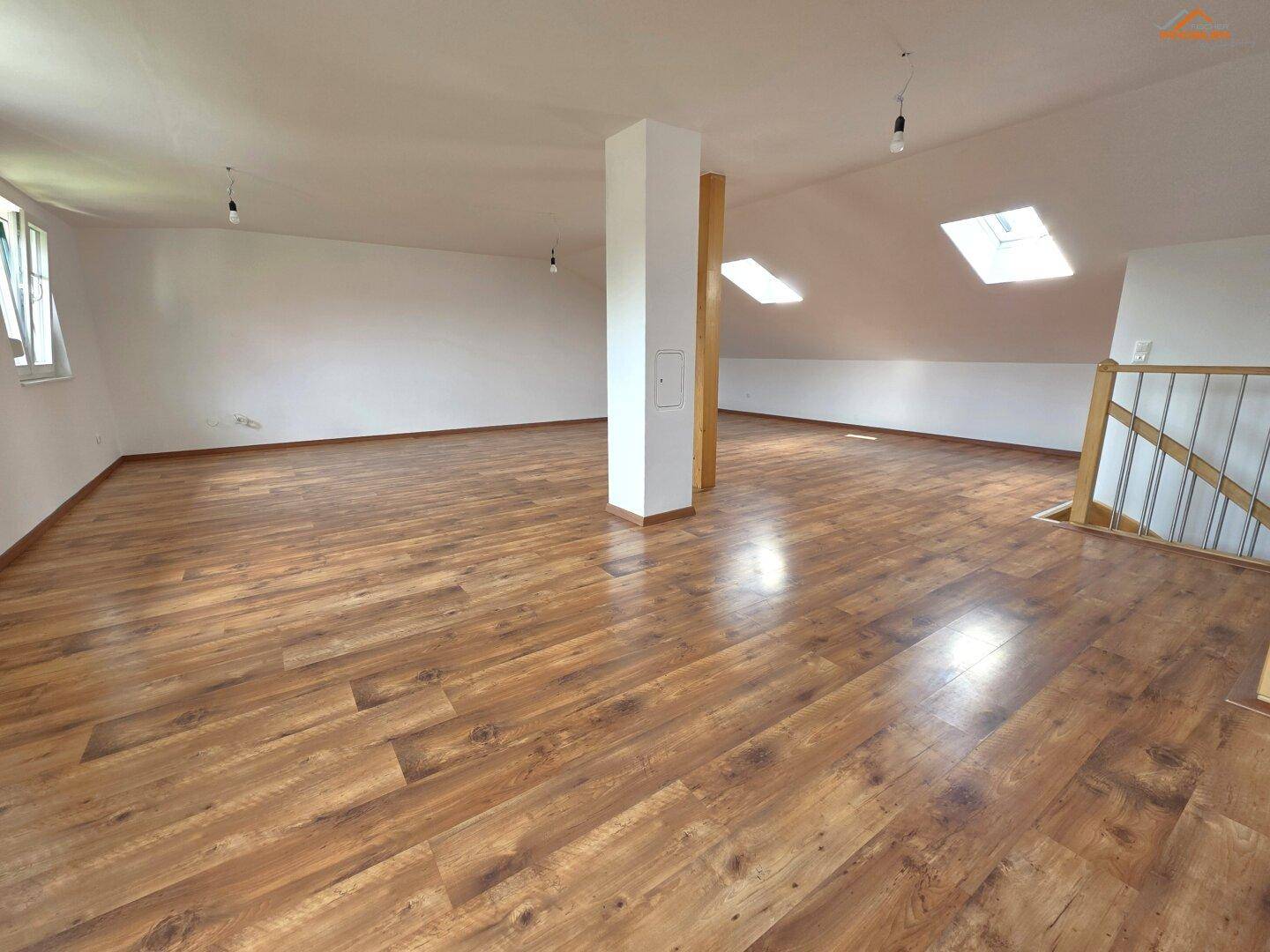 Weitläufiges Dachgeschoss mit Holzboden, Dachfenstern und viel natürlichem Licht.