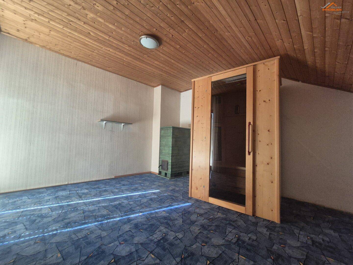 Zimmer mit Holzdecke, Teppichboden und einer eingebauten Sauna für entspannende Momente.