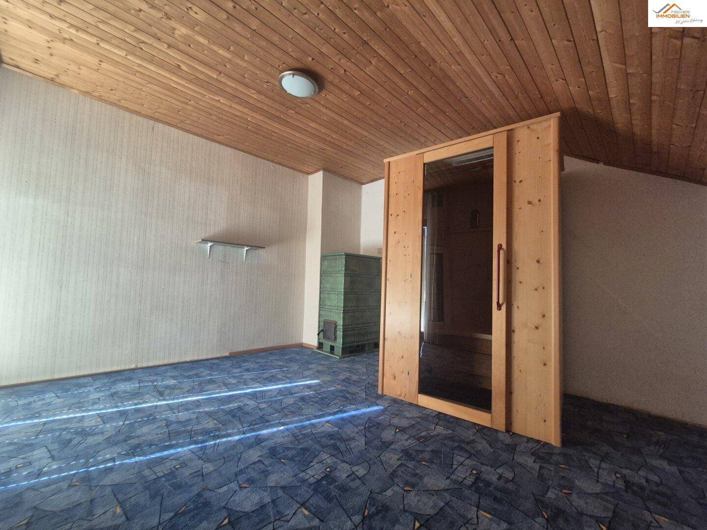 Raum mit Holzdeckenverkleidung, Teppichboden und einer eingebauten Sauna für Wellness.