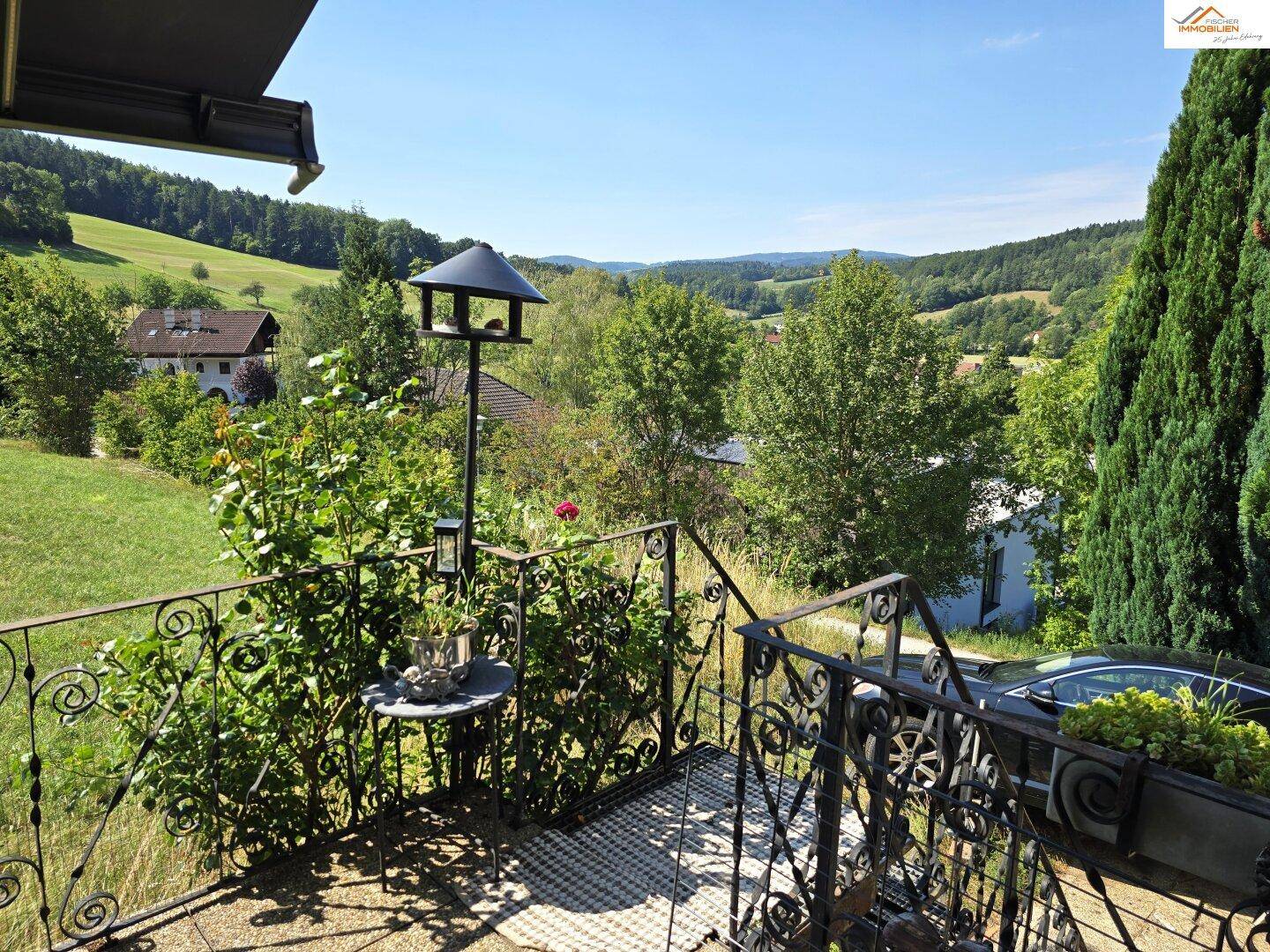 Kleiner Balkon mit schmiedeeisernem Geländer und weitem Blick über die Landschaft.