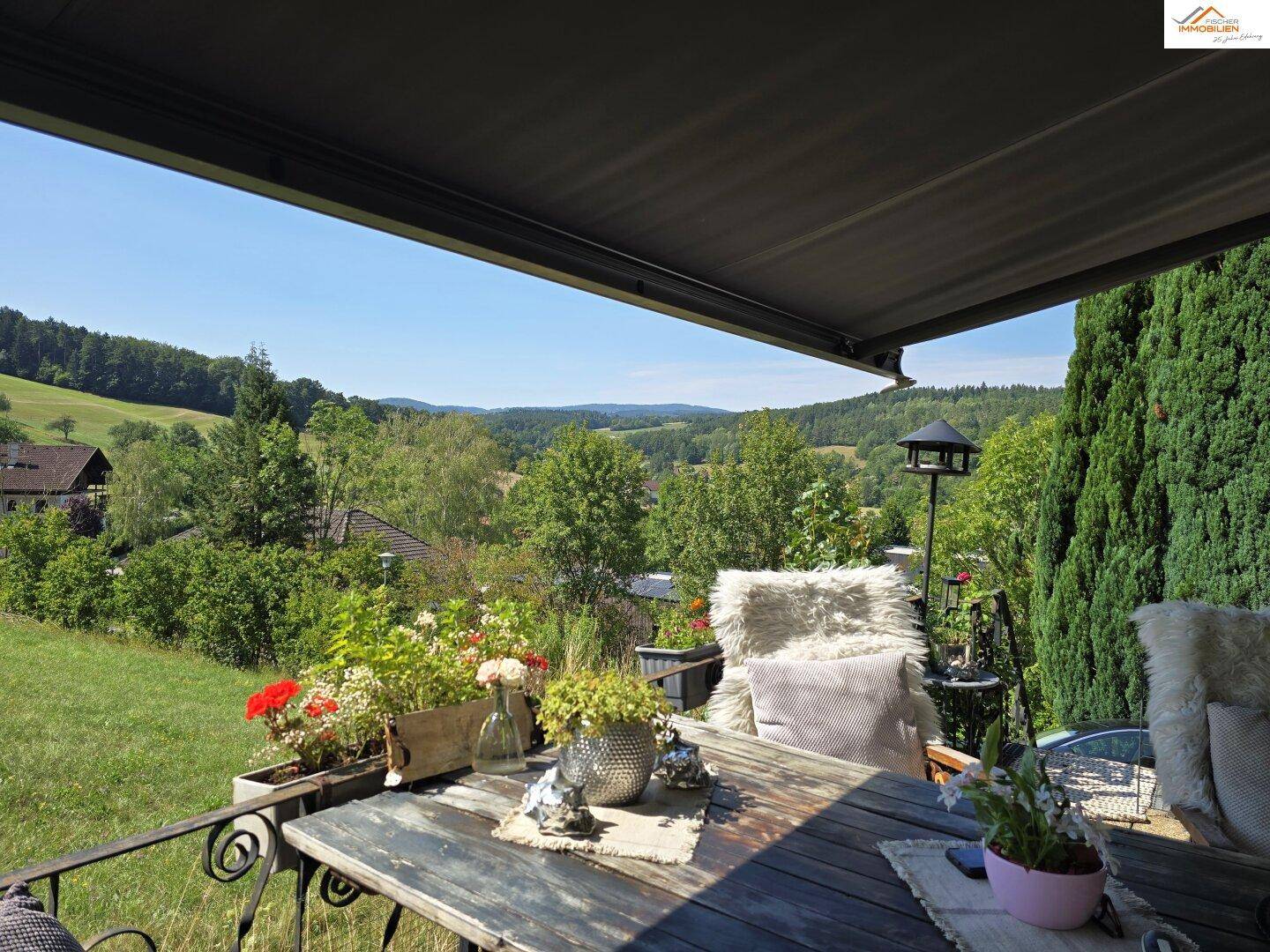 Gemütlicher Balkon mit Markise, Sitzgelegenheiten und weitem Blick ins Grüne.