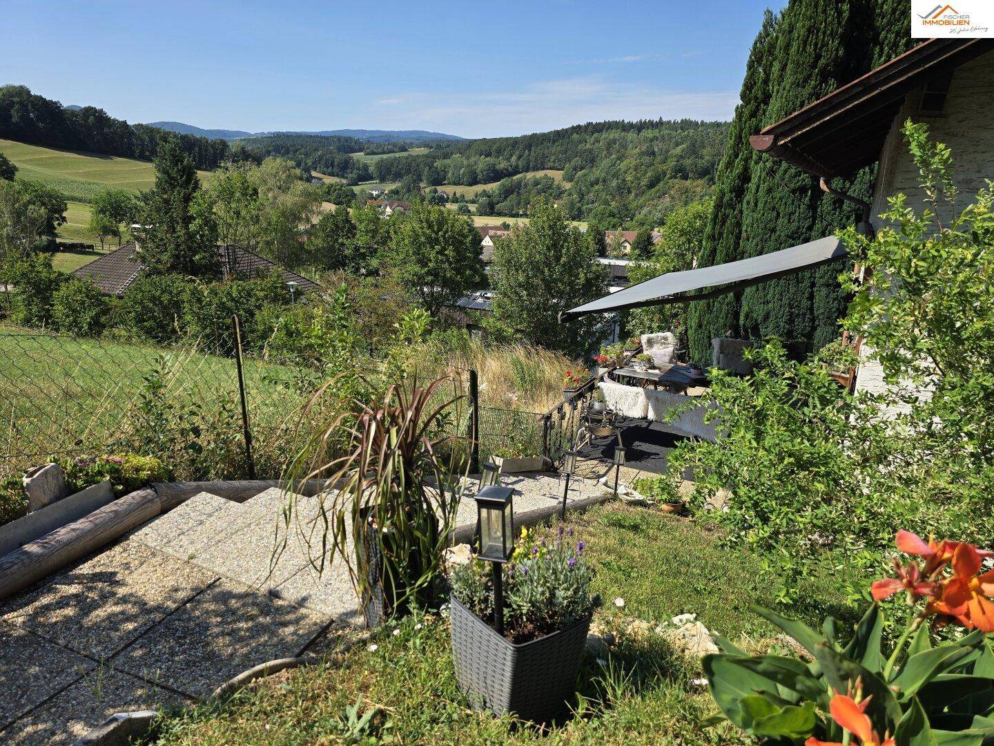 Gartenbereich mit Treppe und Blick auf die umliegende grüne Landschaft.