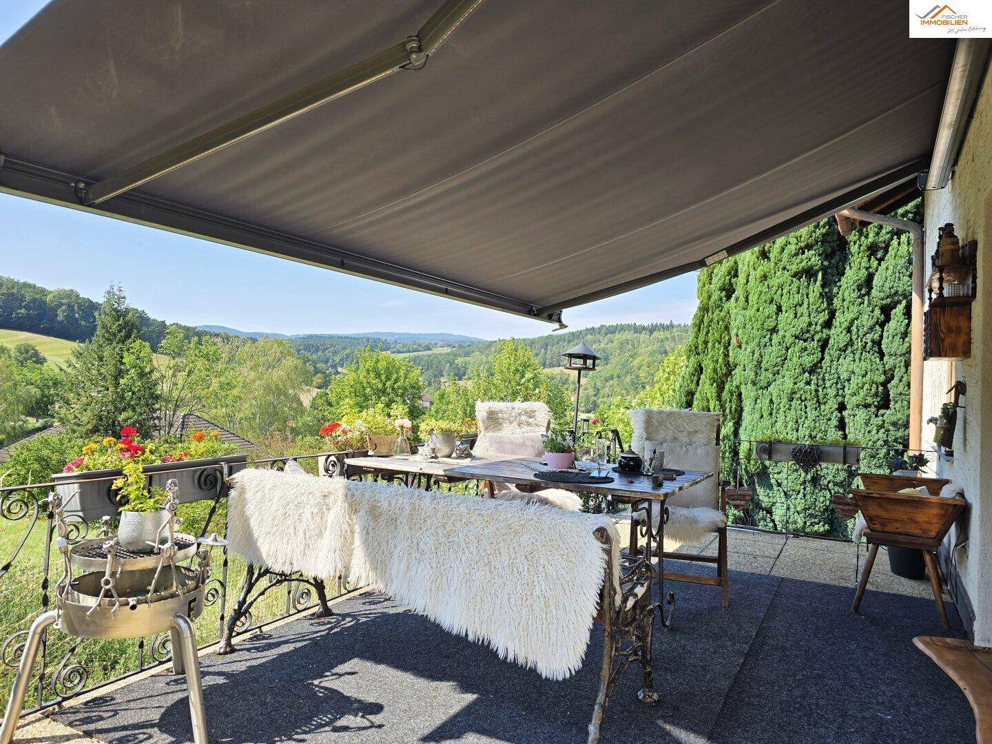 Gemütlicher Balkon mit Markise, Sitzgelegenheiten und weitem Blick ins Grüne.
