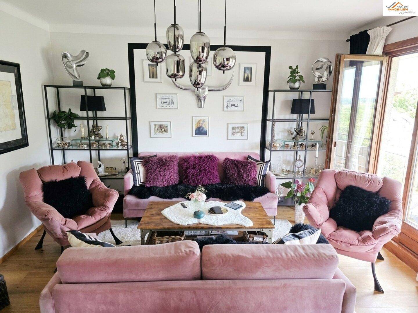 Gemütliches Wohnzimmer mit rosa Sofas, dekorativen Elementen und Zugang zum Balkon.