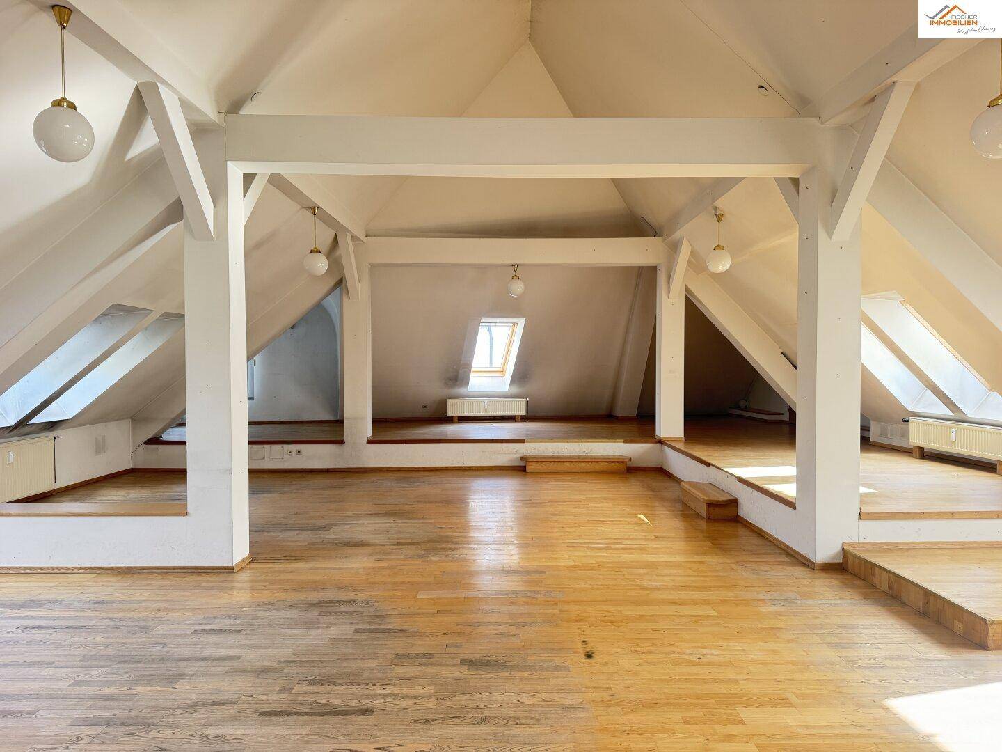 Weitläufiger Dachboden mit sichtbaren Holzbalken und mehreren Ebenen, bietet viel Potenzial.