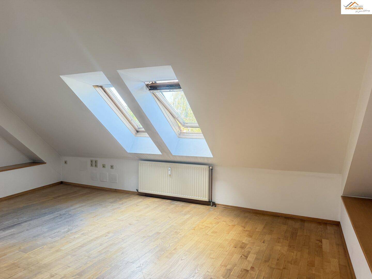 Lichtdurchfluteter Dachraum mit zwei großen Dachfenstern und Heizung, bereit zur Gestaltung.