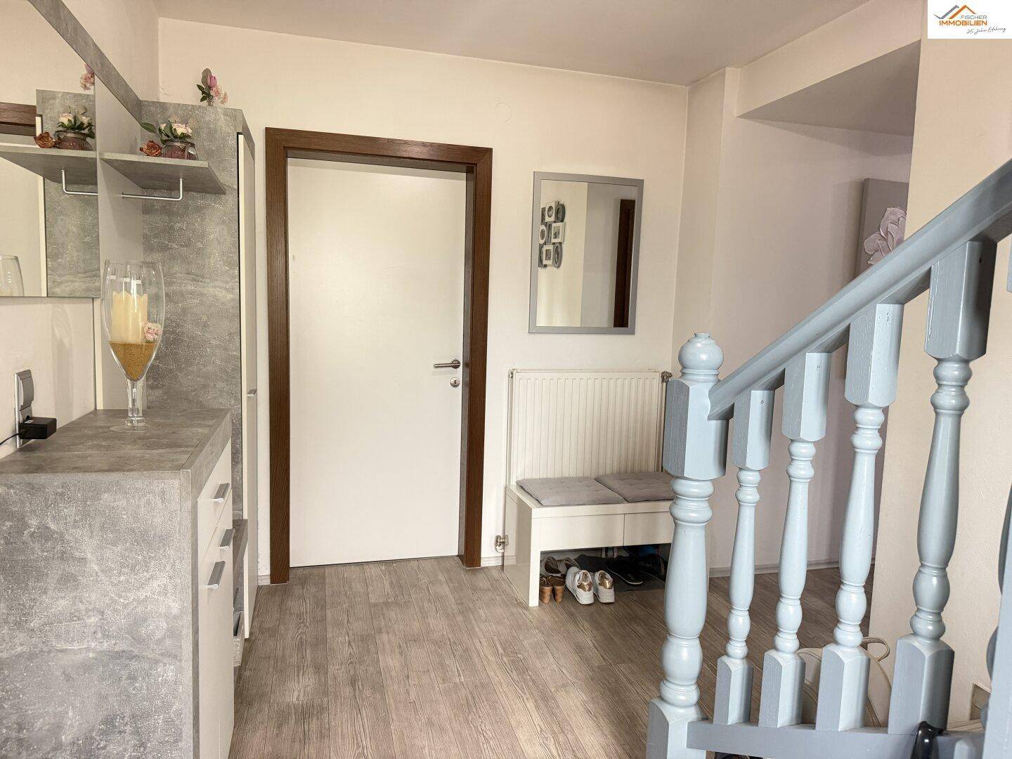 Eingangsbereich mit Garderobe, Treppe und modernem Bodenbelag.