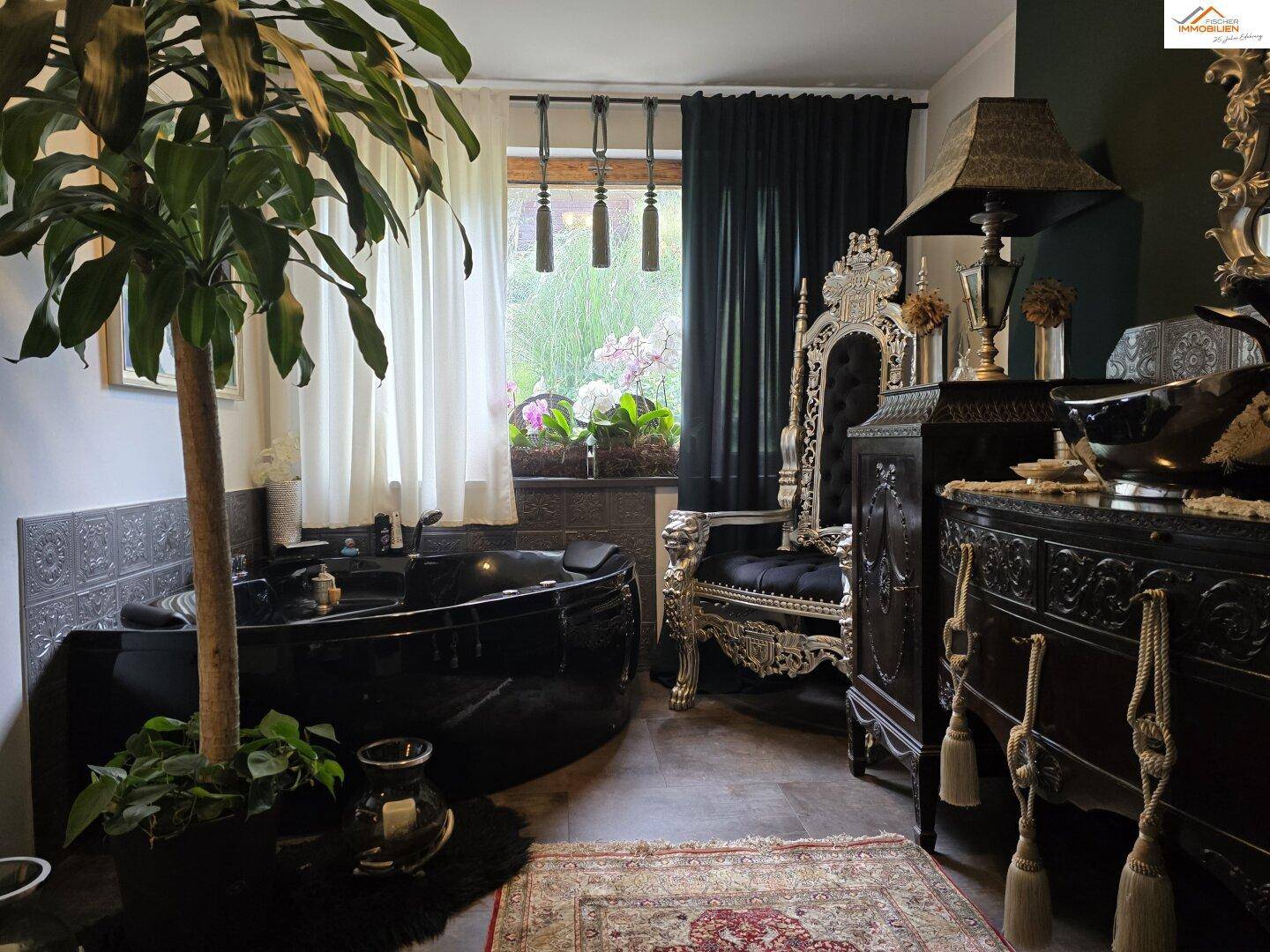 Luxuriöses Badezimmer mit großer schwarzer Badewanne und opulenten Möbeln, umgeben von Pflanzen.