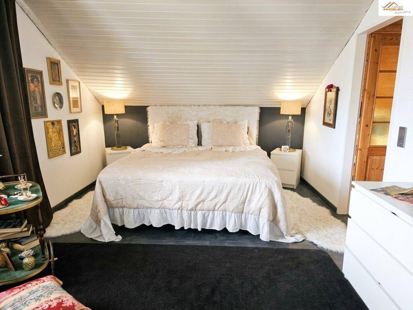 Gemütliches Schlafzimmer im Dachgeschoss mit schrägen Wänden, weichen Teppichen und Doppelbett.