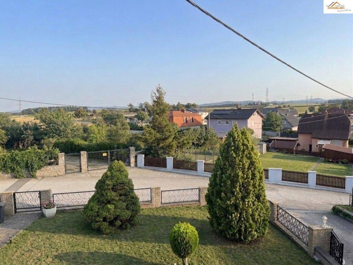 Weitläufiger Blick über die ländliche Umgebung mit Häusern und viel Grün.