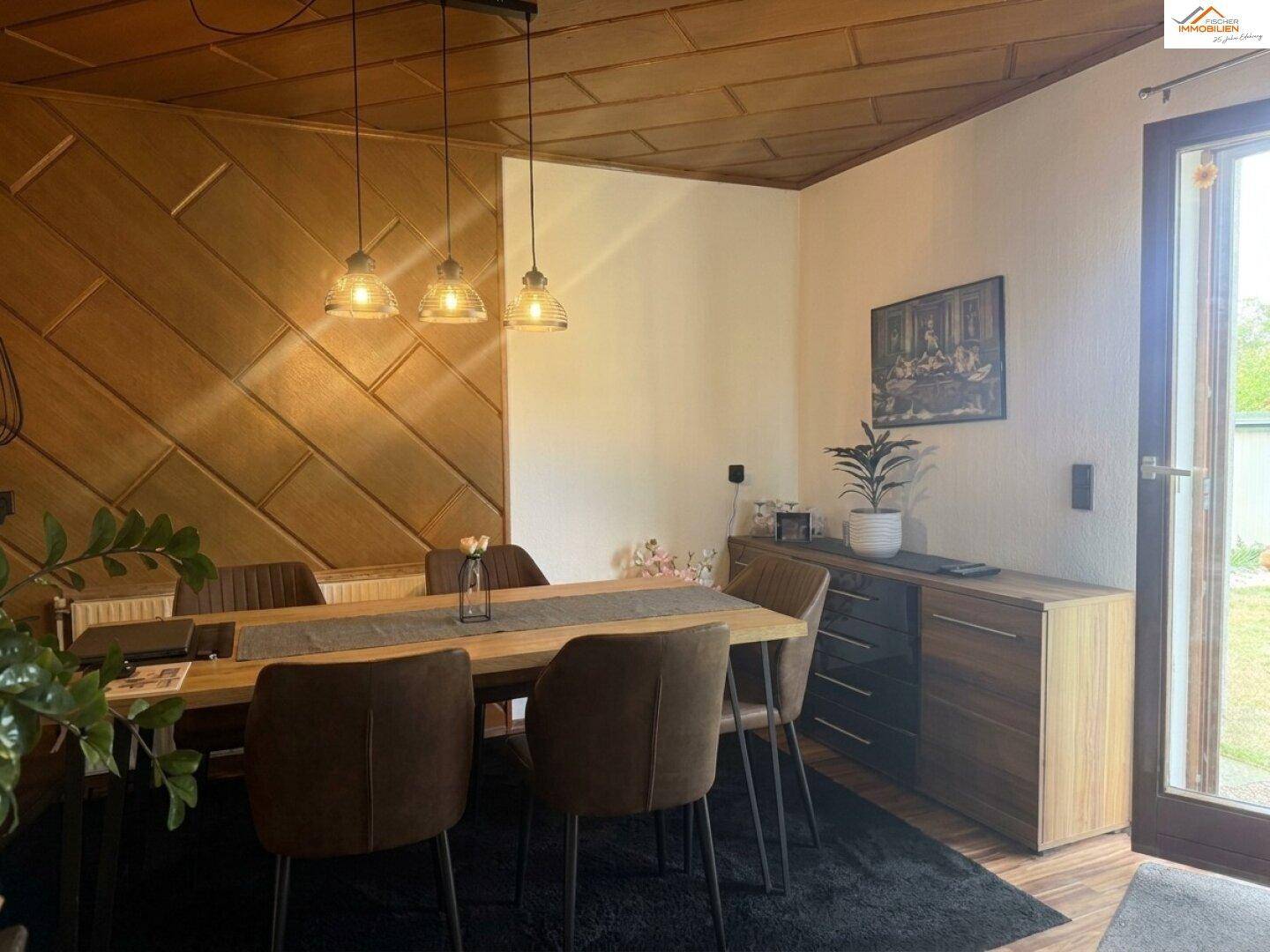 Gemütlicher Essbereich mit Holztisch, modernen Stühlen und dekorativer Wandverkleidung.