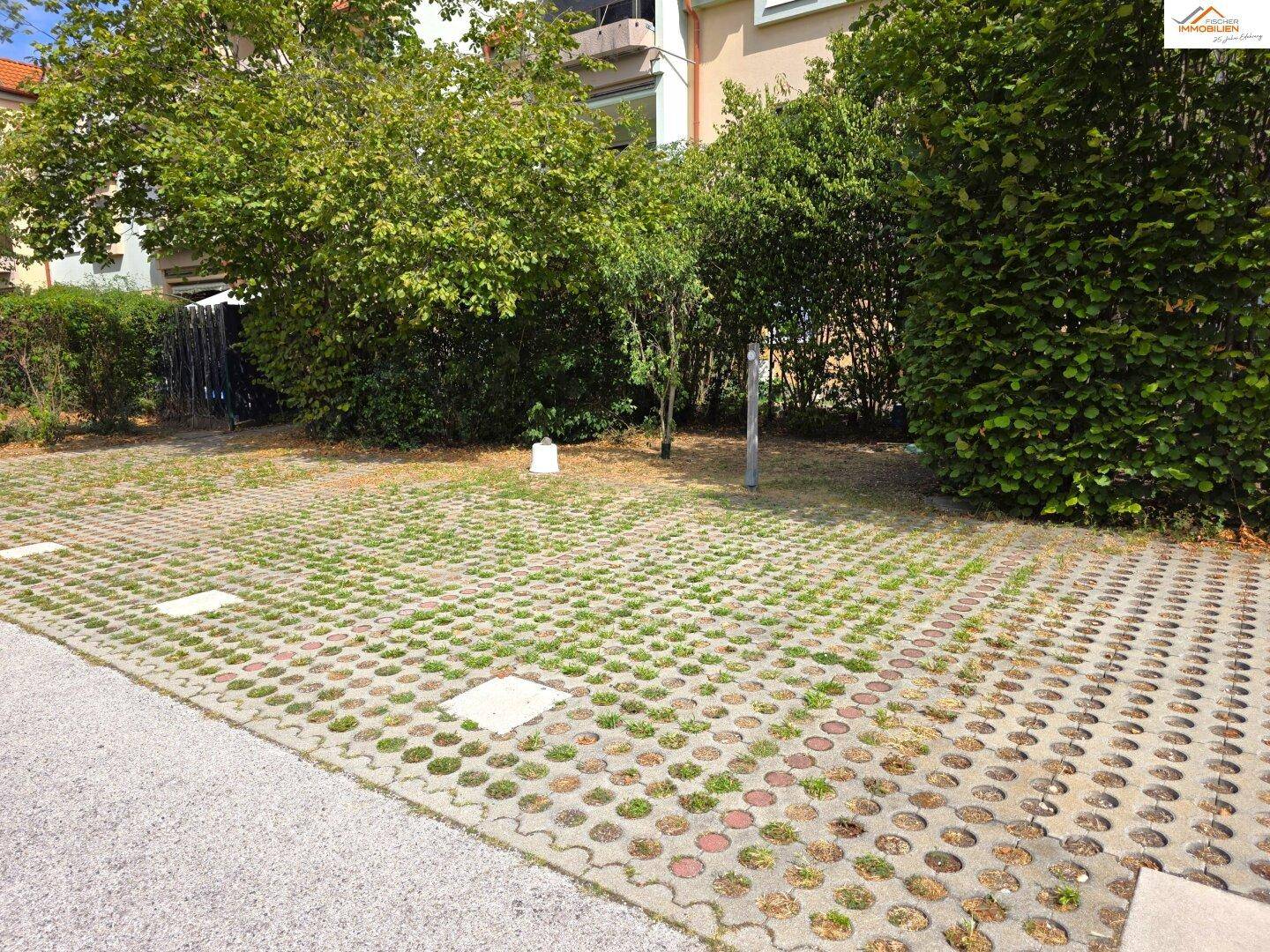 Außenparkplätze mit Rasengittersteinen und umgebender Bepflanzung.