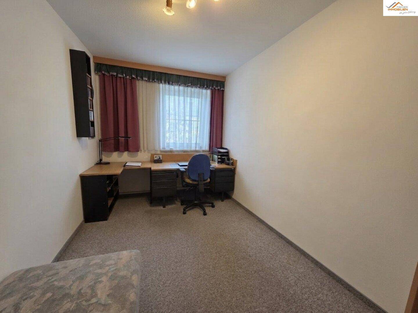 Arbeitszimmer mit Teppichboden, Schreibtisch und Fenster, ideal für Home-Office.