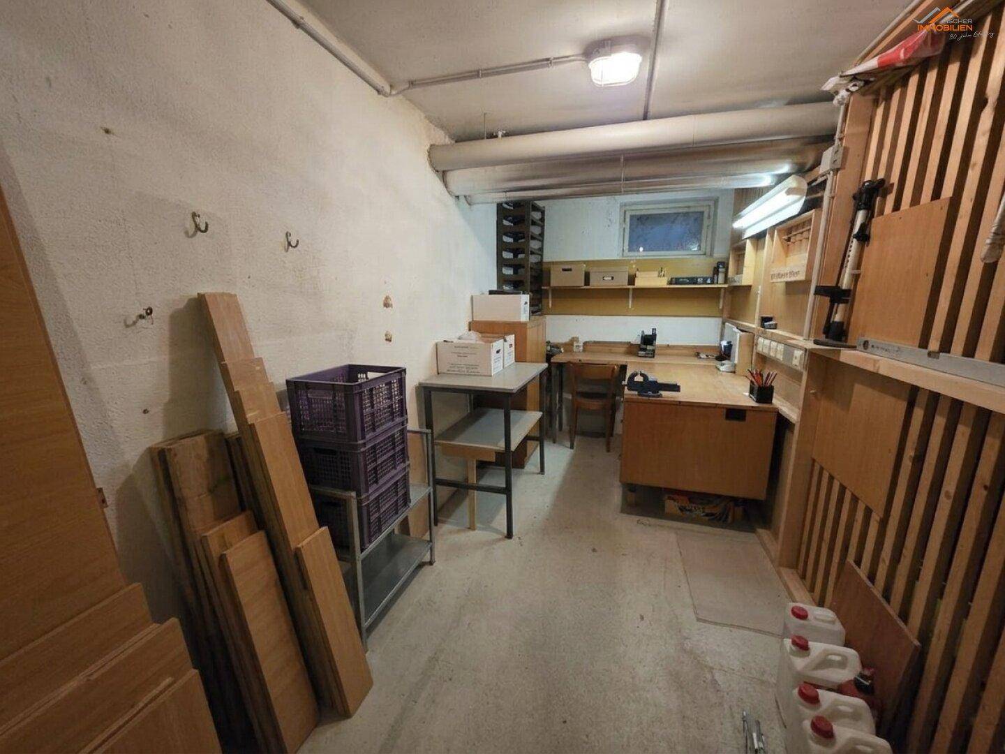 Geräumiger Hobbyraum im Keller mit Werkbänken und Stauraum für verschiedene Materialien.
