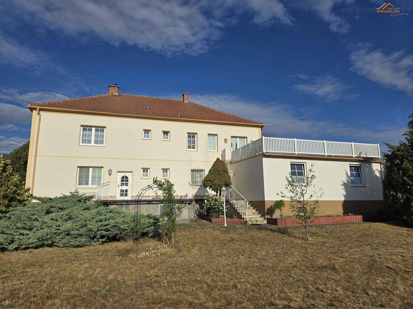 Ansicht des Wohngebäudes von der Gartenseite mit Terrasse und Zugang zum Garten.