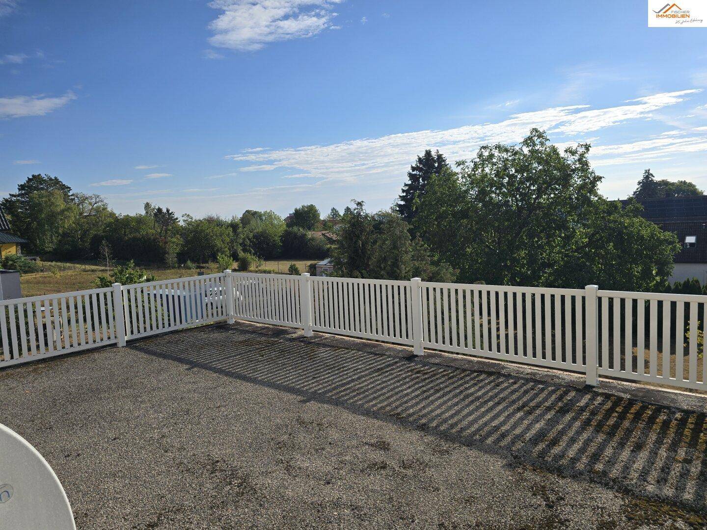 Weitläufige Dachterrasse mit weißem Geländer und Panoramablick auf die umliegende Landschaft.