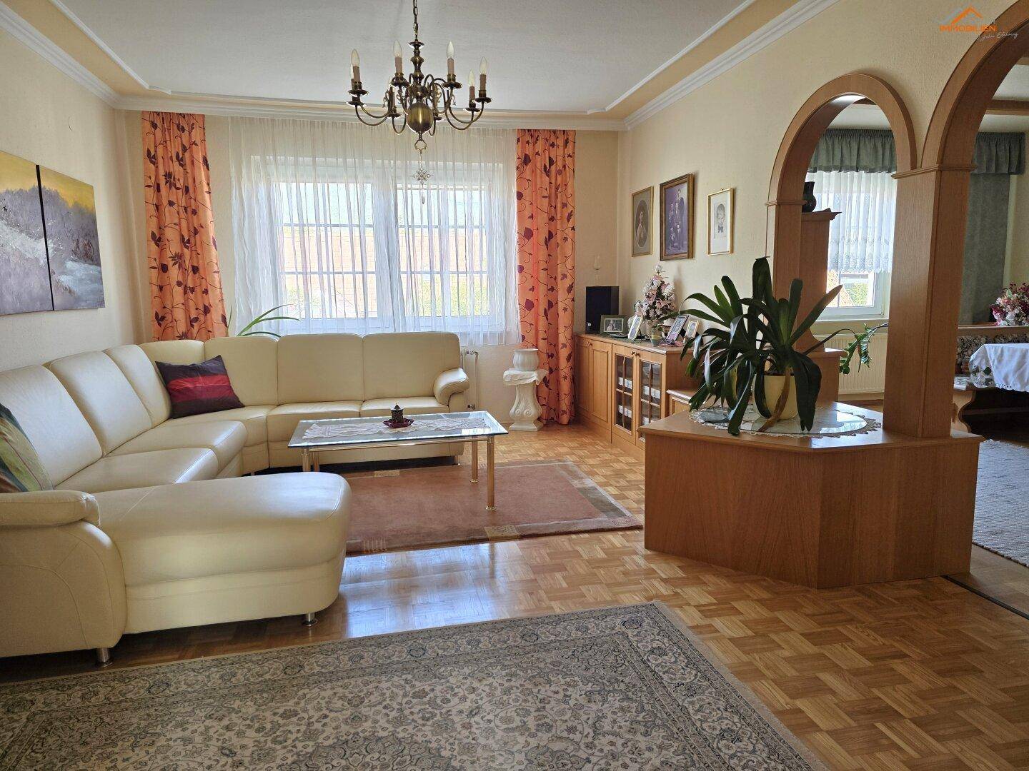 Gemütliches Wohnzimmer mit Ecksofa, Parkettboden und traditioneller Einrichtung, hell und einladend.