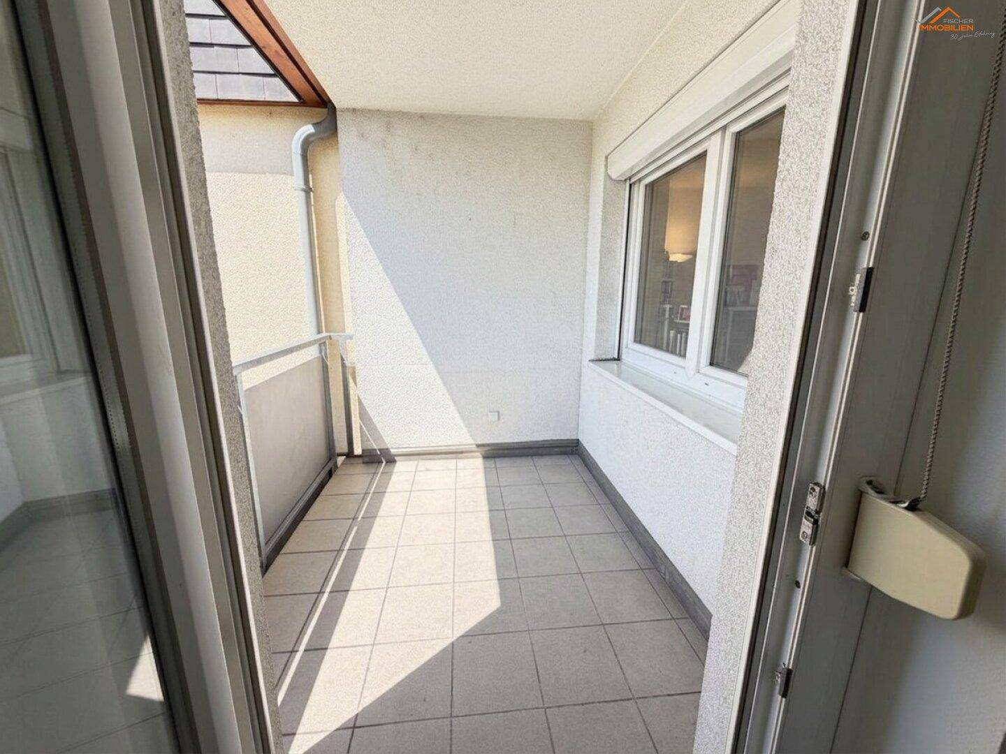 Überdachter Balkon mit Fliesenboden und Metallgeländer, ideal für entspannte Stunden im Freien.