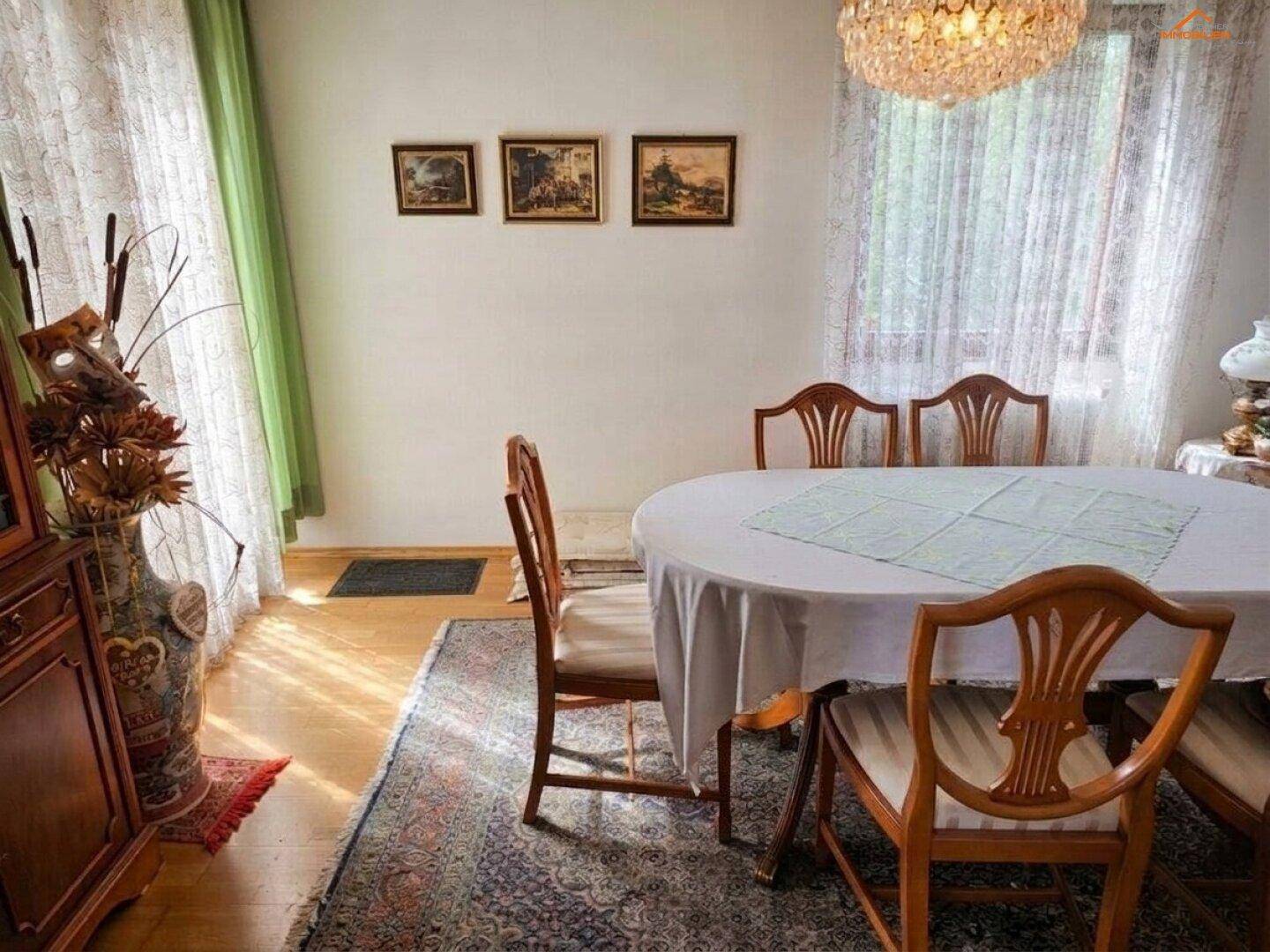 Heller Essbereich mit klassischem Holztisch, Stühlen und Blick ins Grüne.