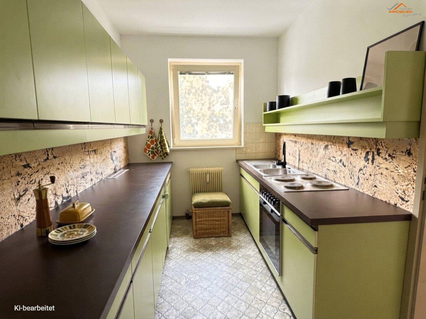 Schmale Küche mit grünen Schränken, brauner Arbeitsplatte und einem Fenster mit Blick ins Grüne.