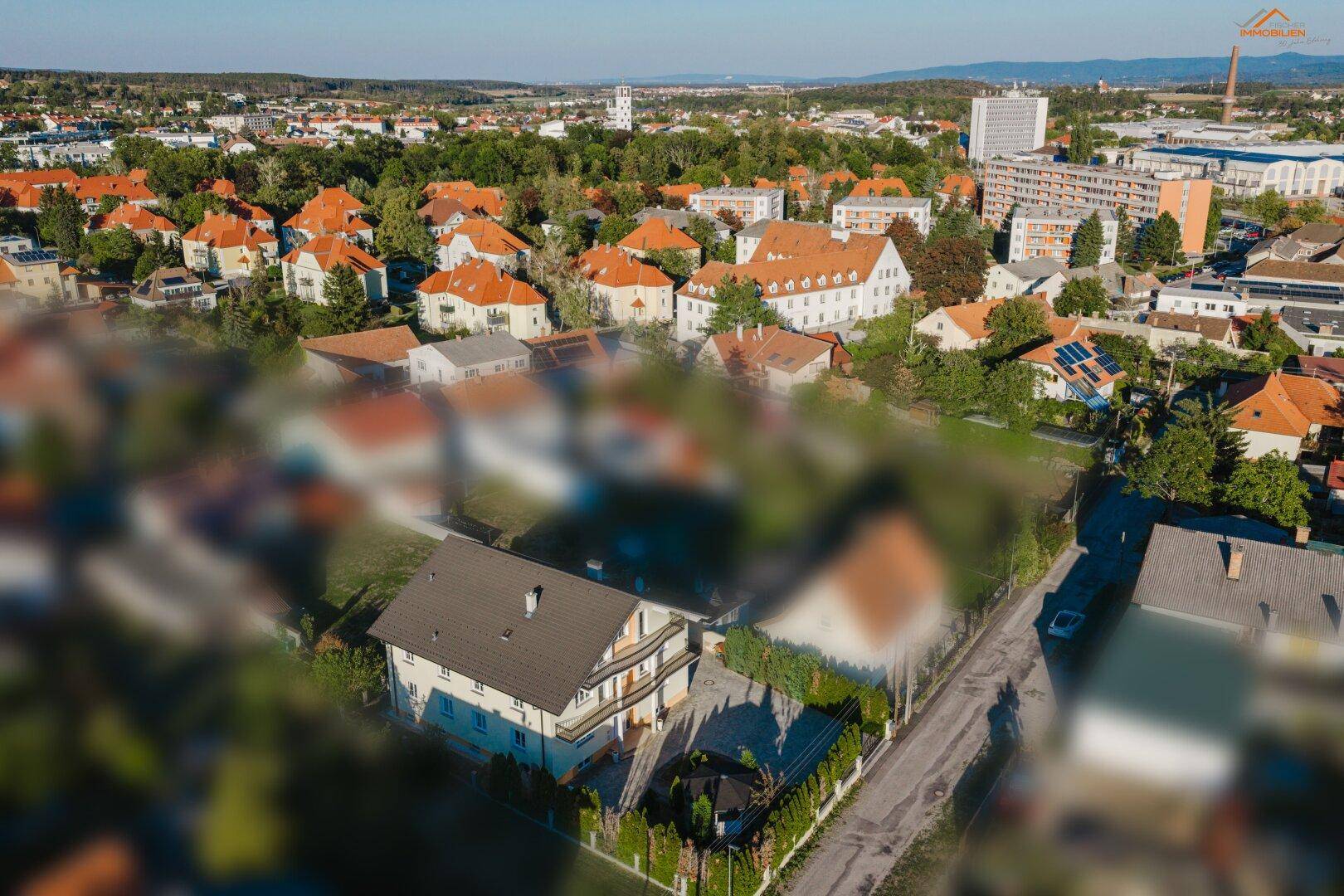 Weitläufige Luftaufnahme eines Wohnhauses mit Blick auf die umliegende Stadt und Landschaft.