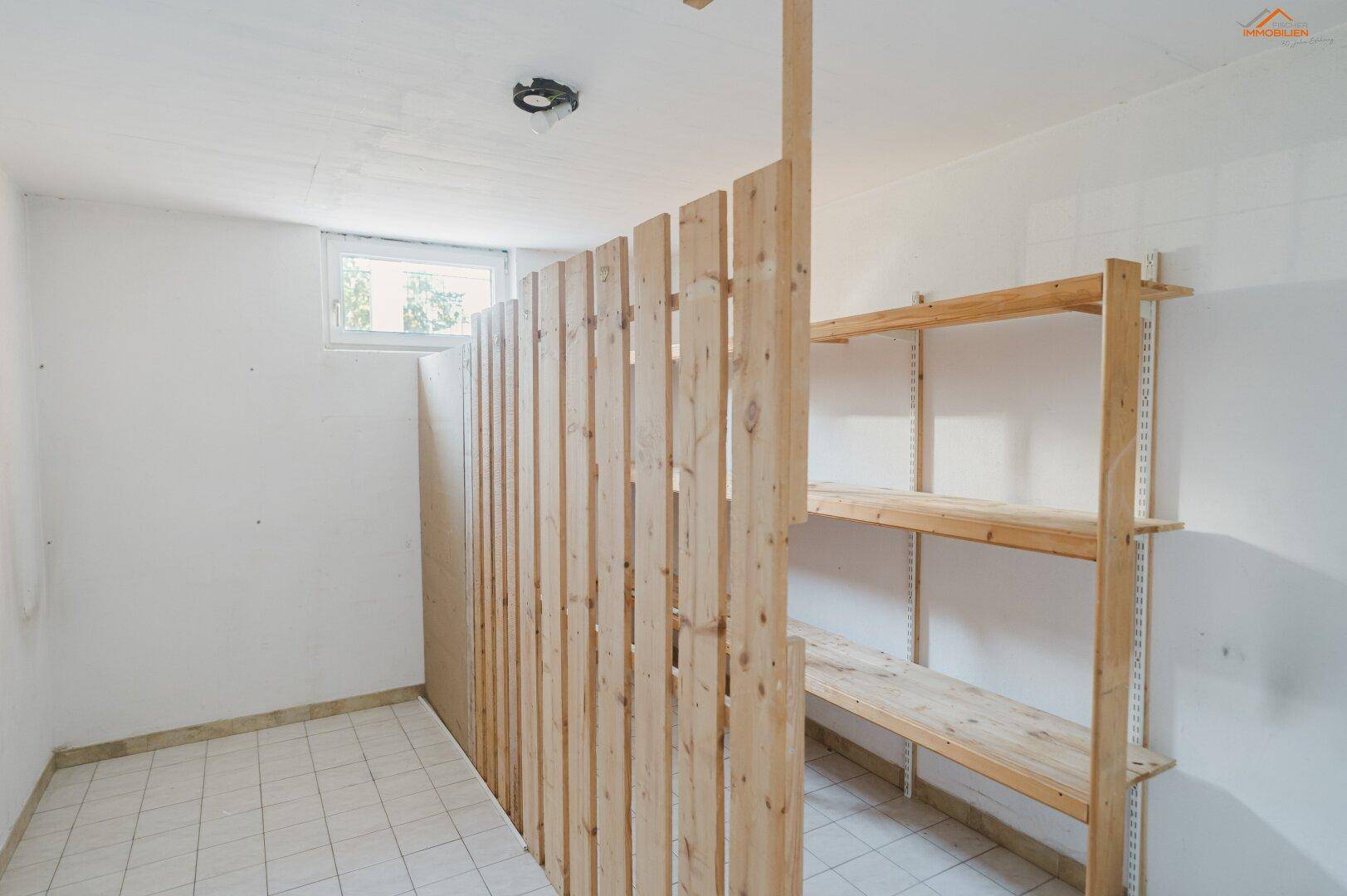 Kellerraum mit Holzregalen und einer Holztrennwand, ideal für zusätzlichen Stauraum.