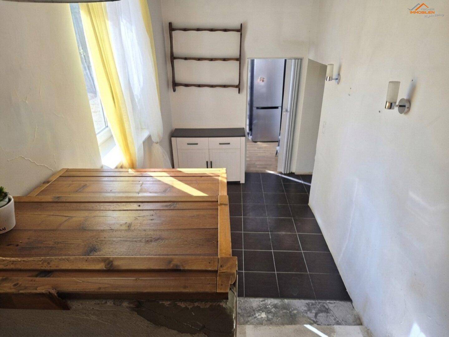 Heller Flur mit Fliesenboden und Zugang zu einem weiteren Raum.