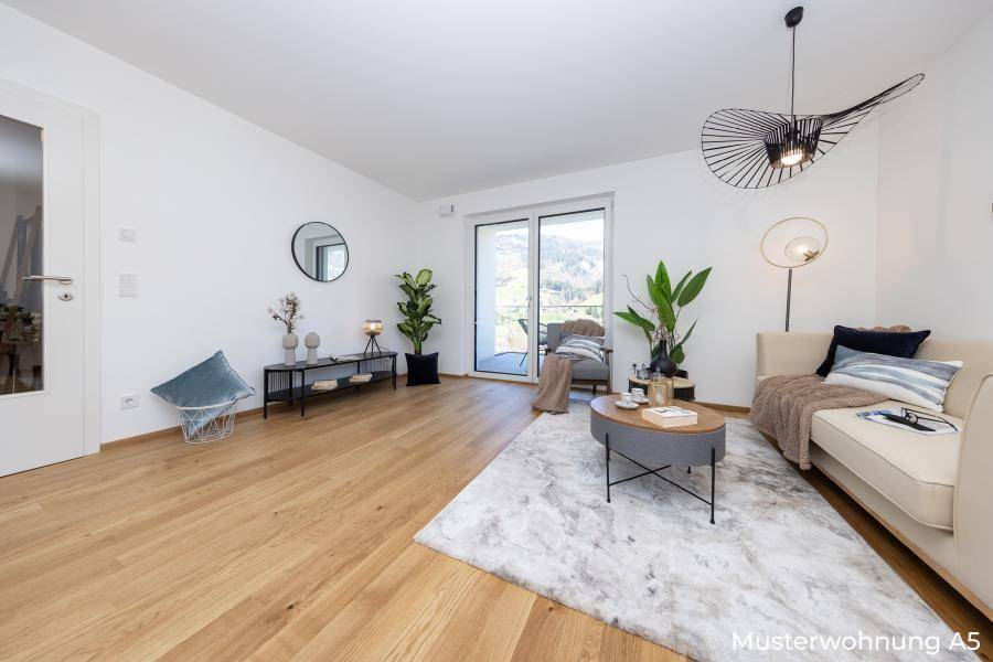 Geräumiges Wohnzimmer mit Eichenparkett, großen Fenstern und Zugang zum Balkon.